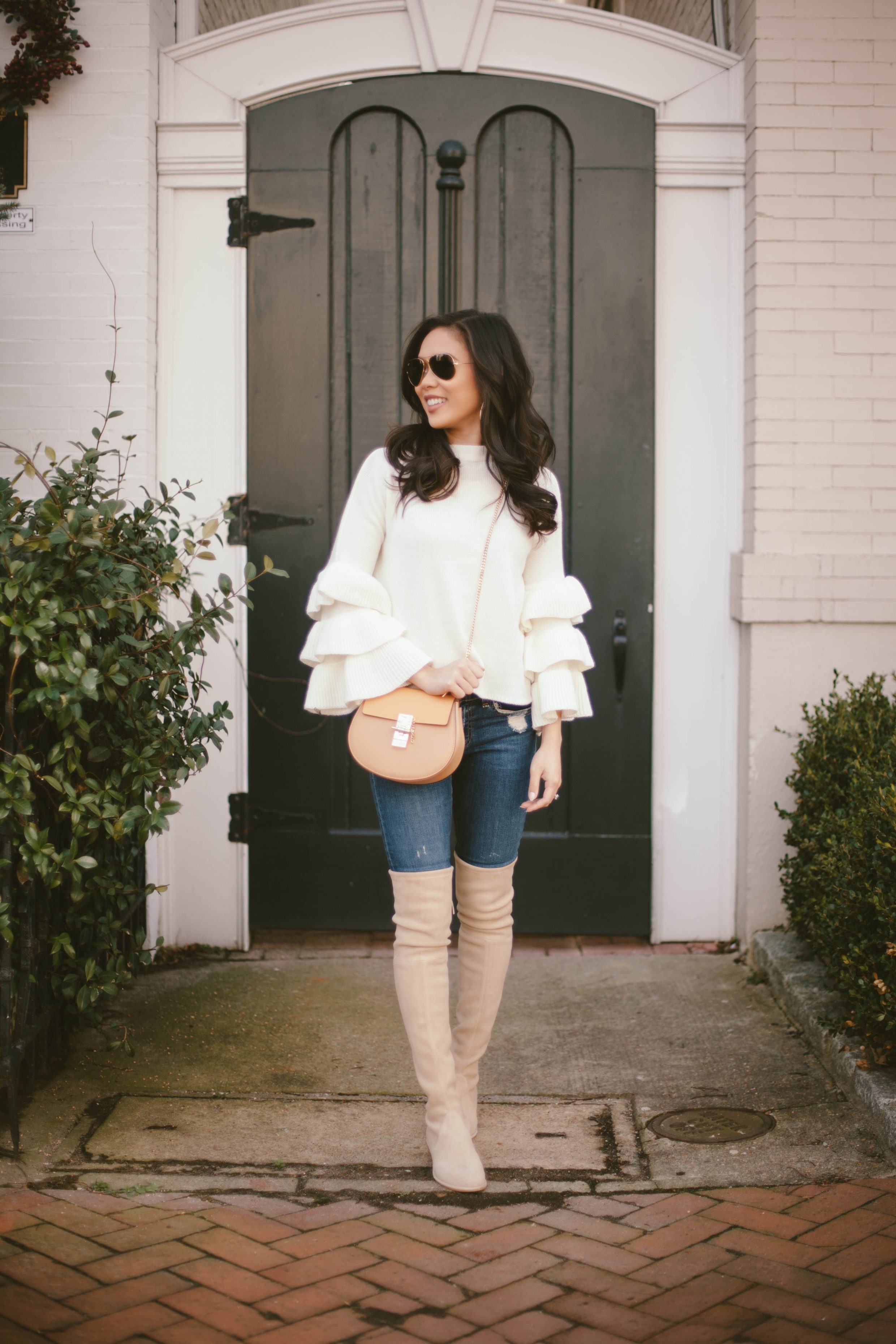 Hoang-Kim wears a ruffle sleeve sweater with over-the-knee boots in buff suede
