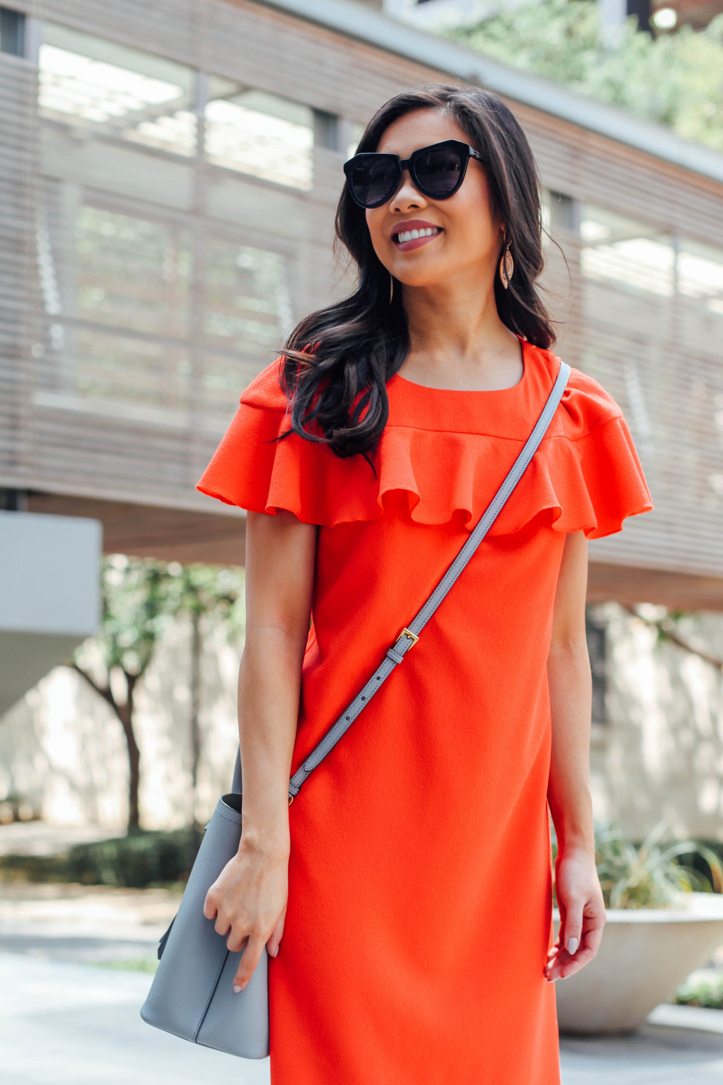 Blogger Hoang-Kim wears a bright orange ruffle dress for spring