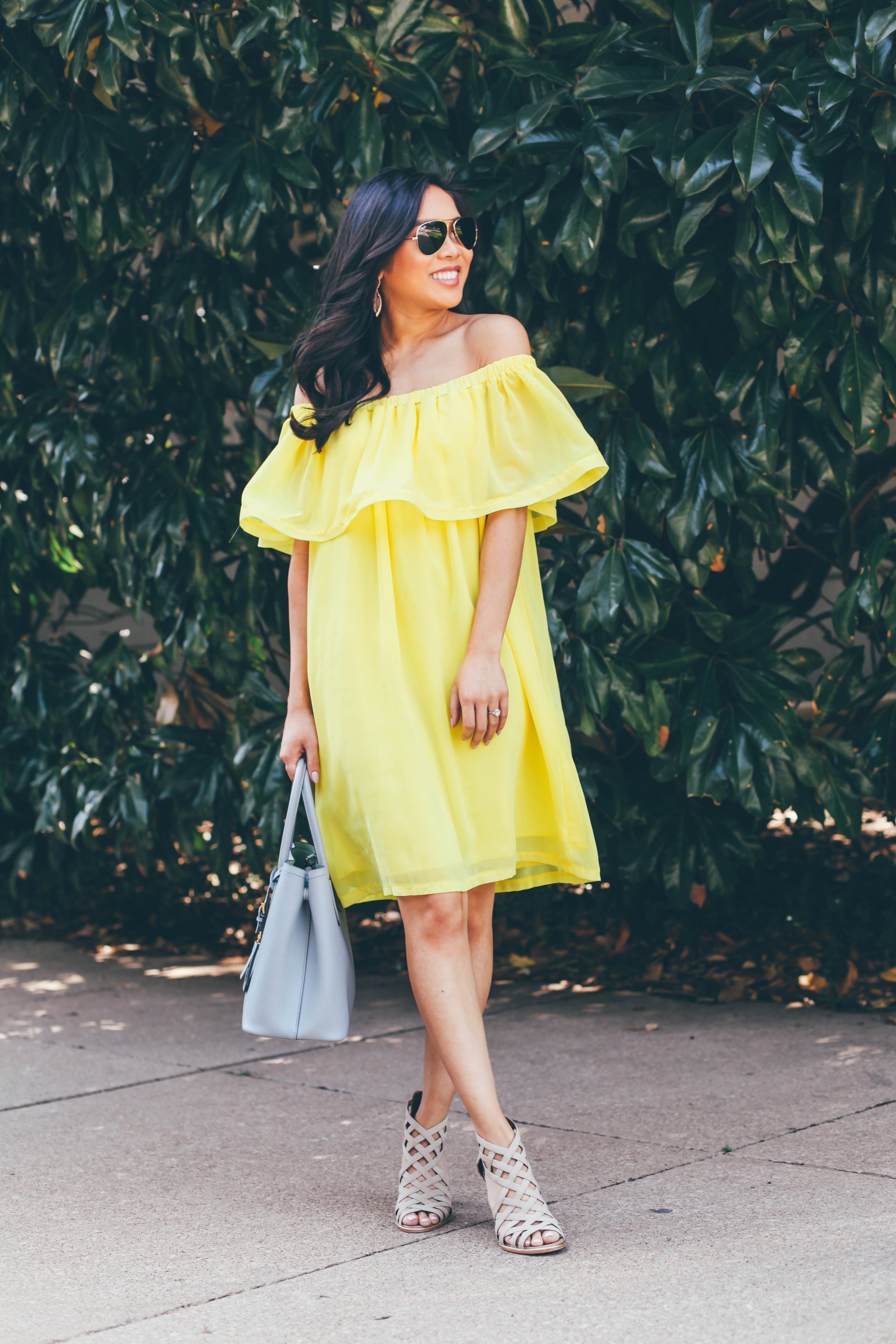 Blogger Hoang-Kim wears a yellow ruffle off the shoulder dress with booties