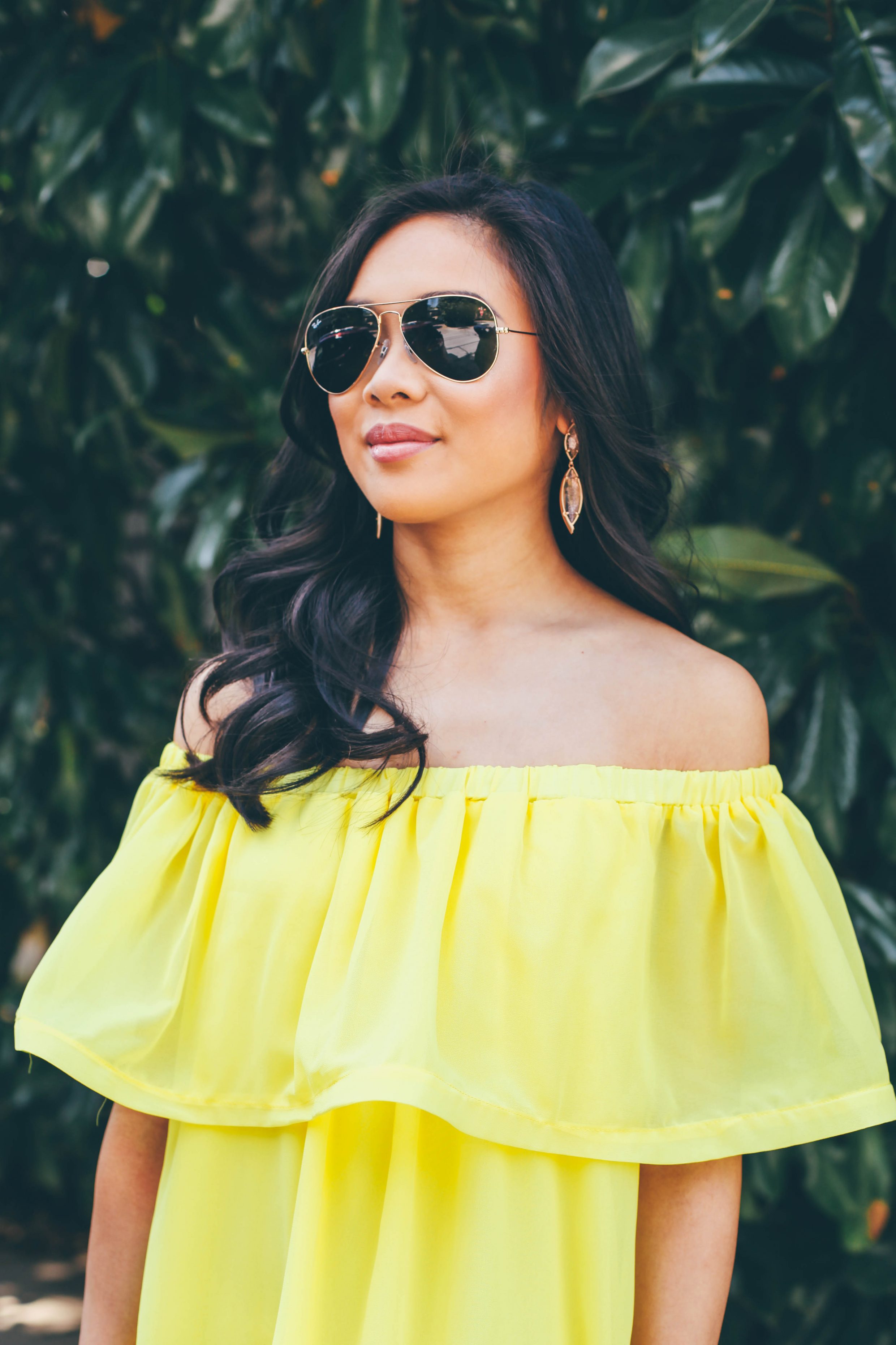 Blogger Hoang-Kim wears a yellow ruffle off the shoulder dress