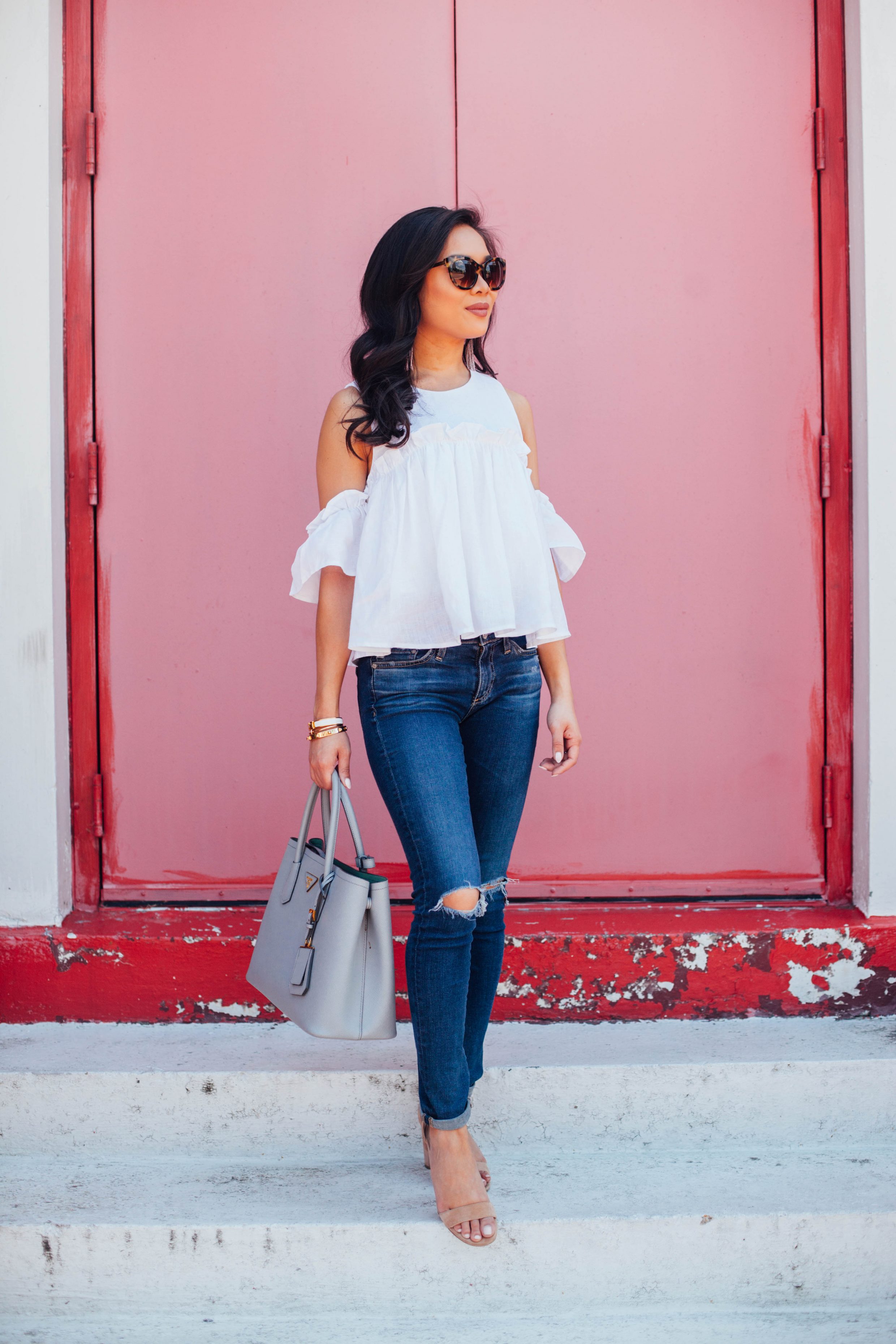 Blogger Hoang-Kim wears a layered ruffle cold shoulder top with distressed jeans