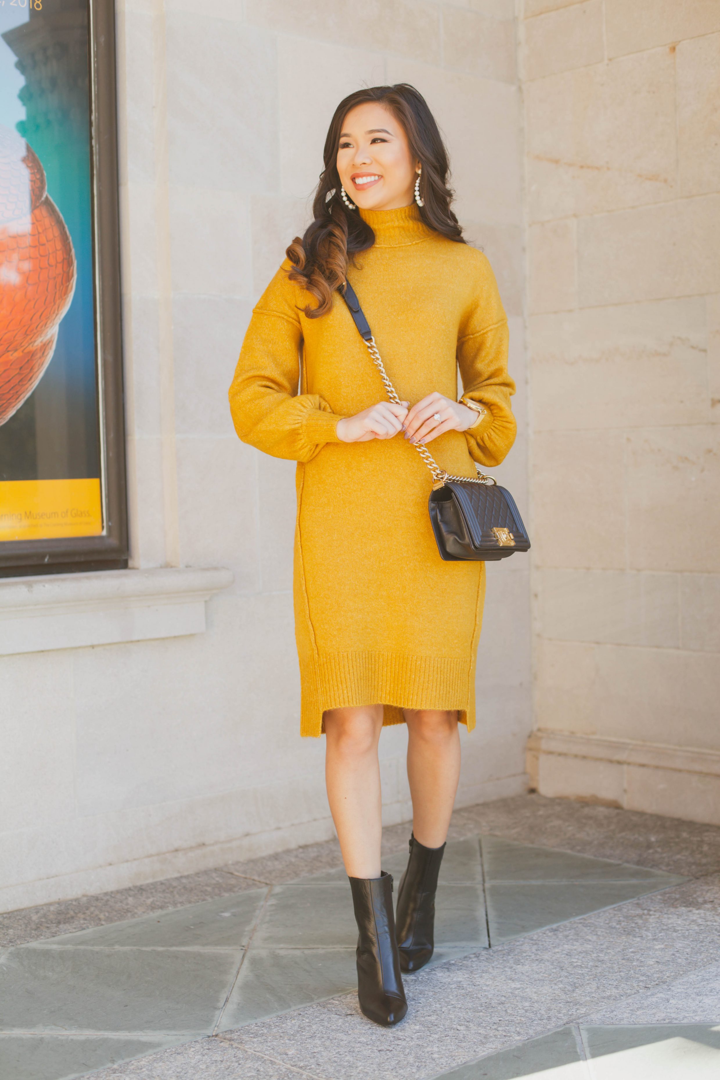 Balloon sleeve sweater dress with gold-tone booties and pearl earrings
