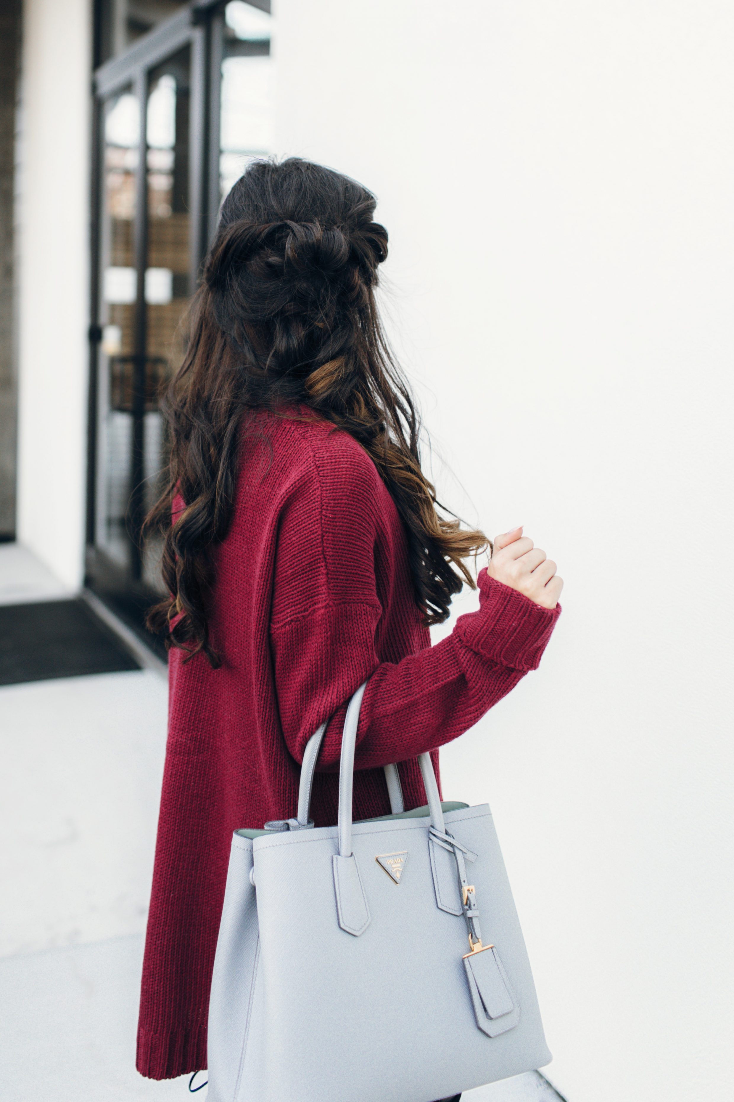 Maroon sweater with messy braid and Prada Cuir tote