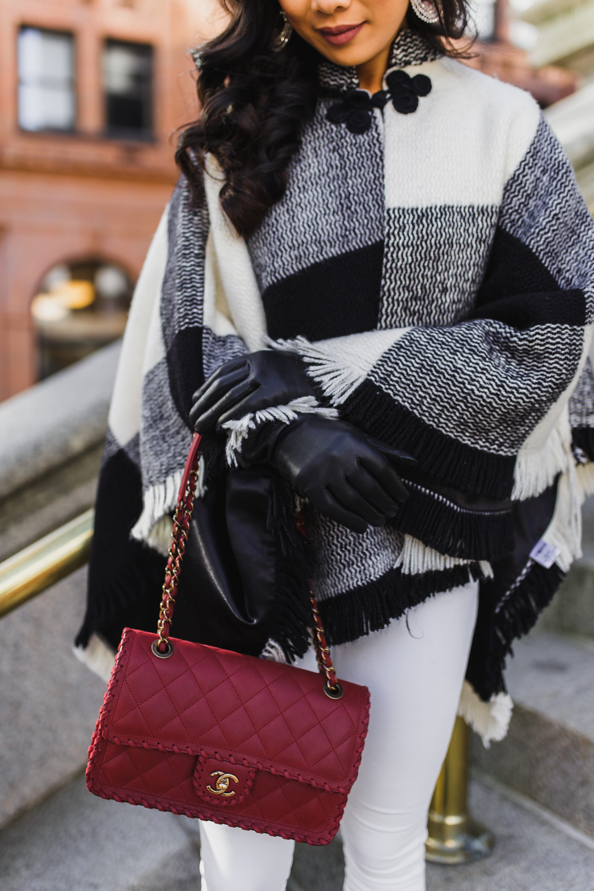 Black and white poncho with cashmere lined gloves and red Chanel flap bag