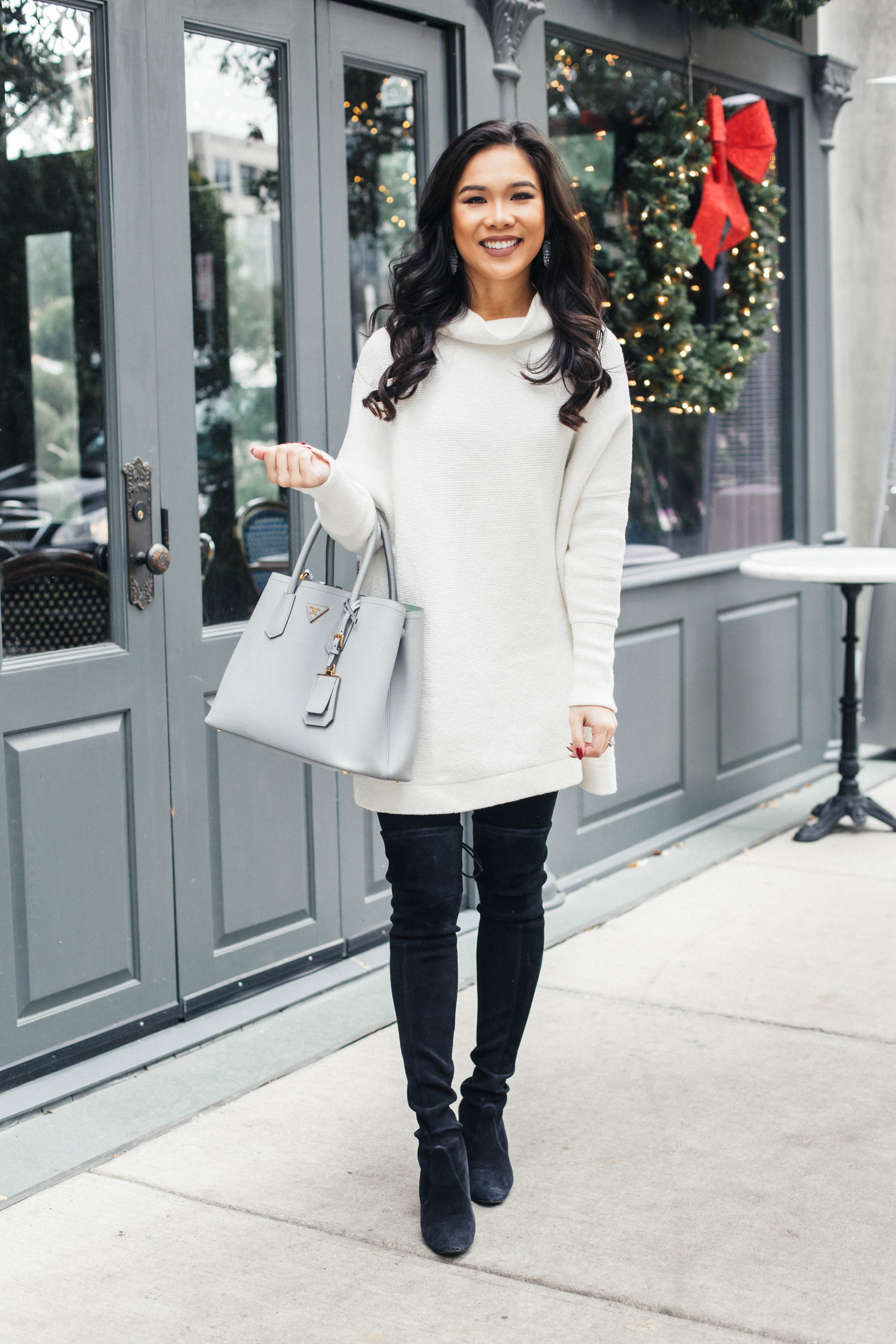 White slouchy tunic with black over the knee boots
