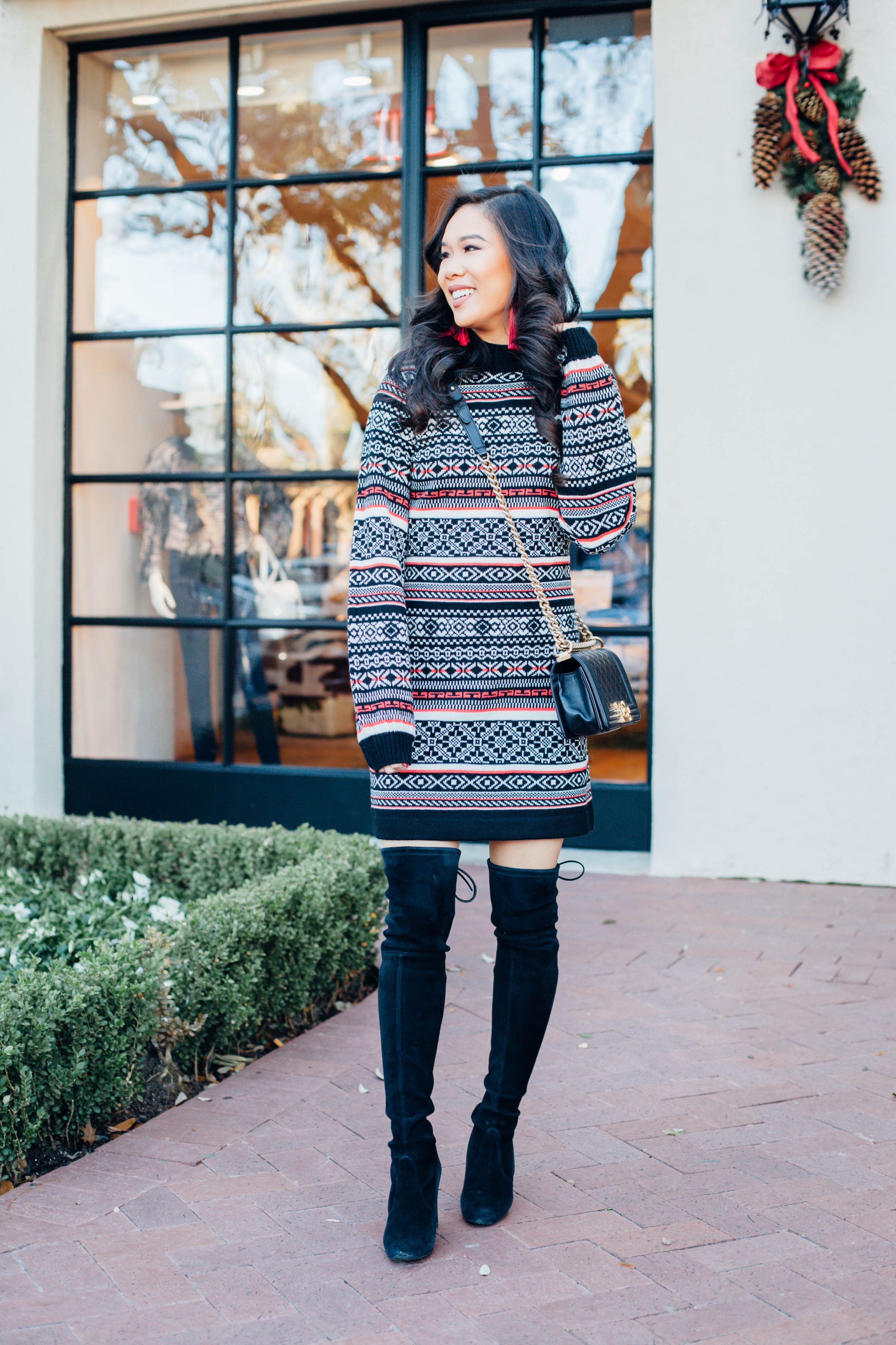 Fair Isle sweater dress with over the knee boots and red tassel earrings