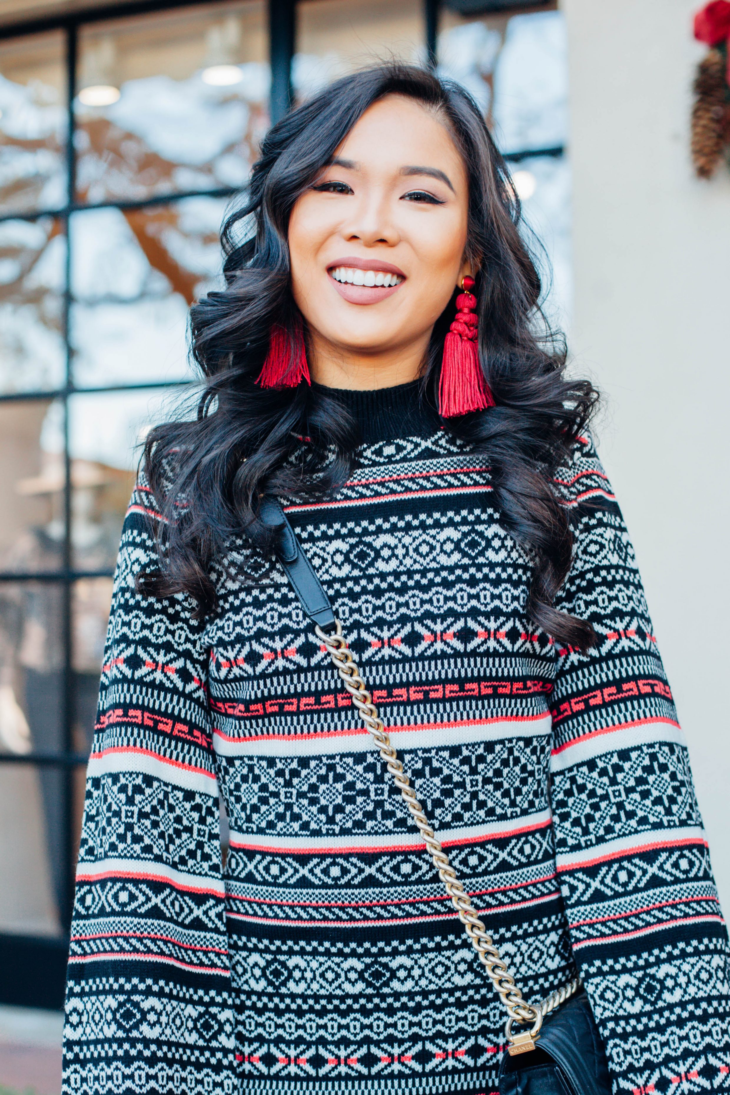 Fair Isle sweater dress with over the knee boots and red tassel earrings