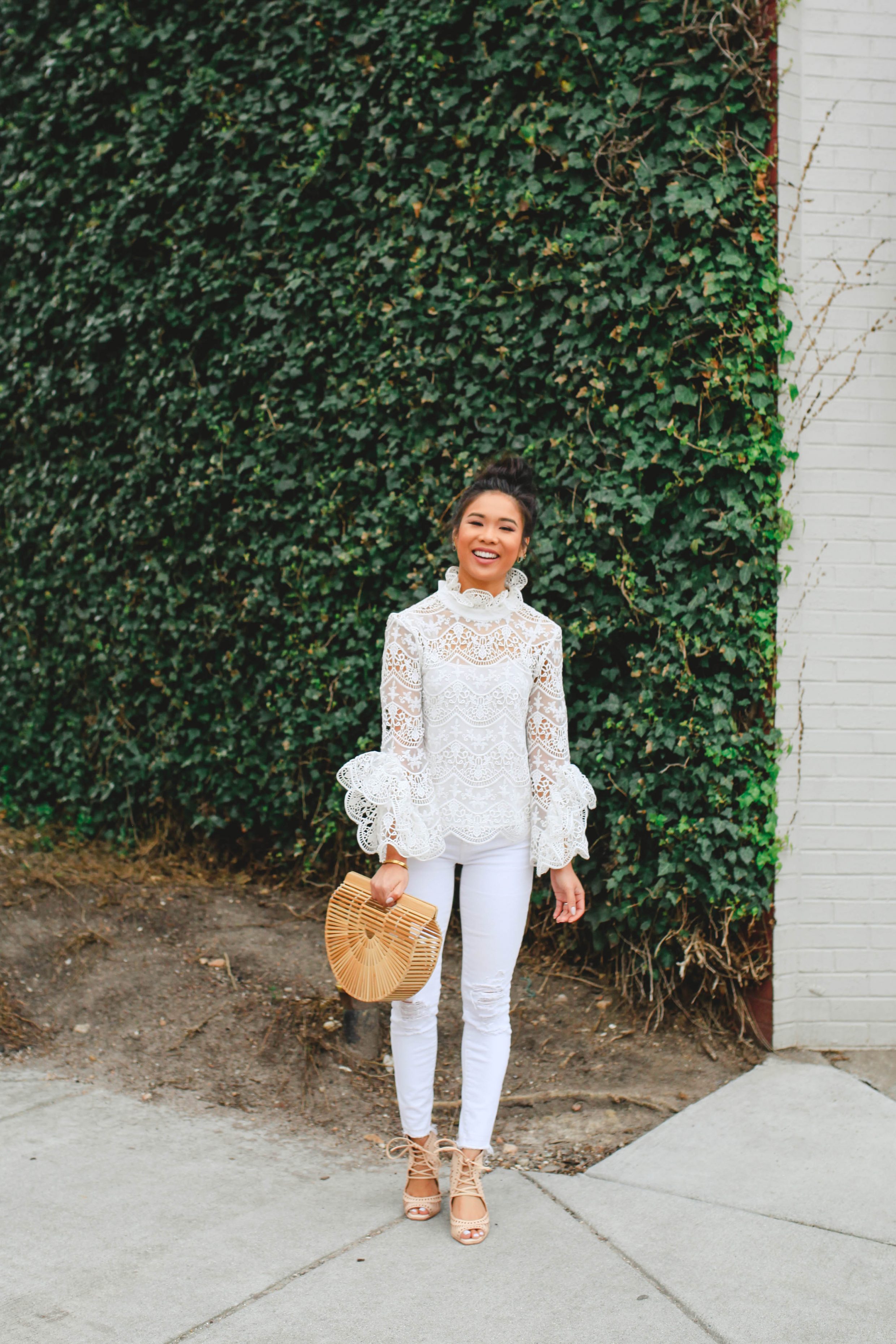 Hoang-Kim Cung wears a lace crochet top with white jeans and Cult Gaia Ark bag