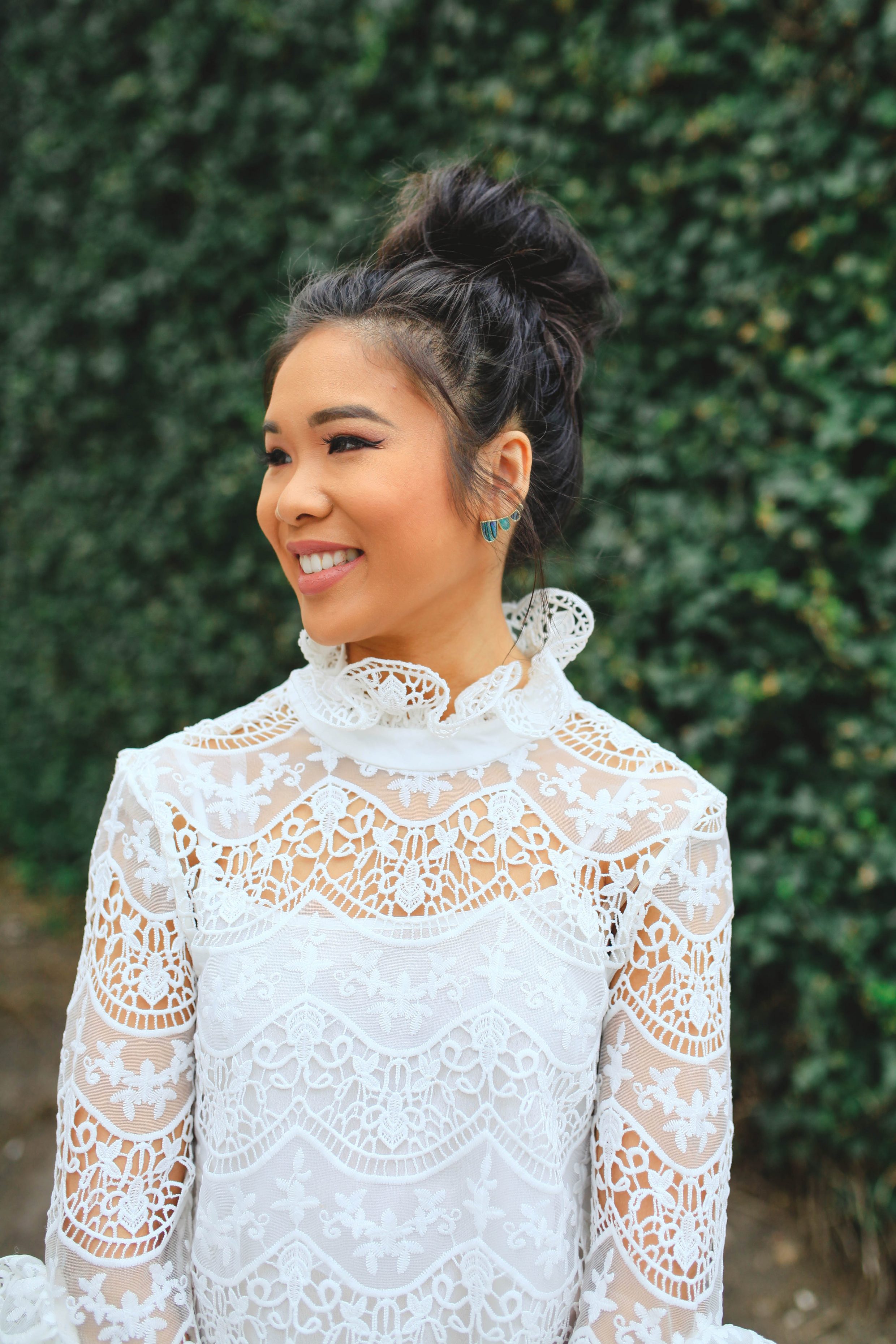 Hoang-Kim Cung wears a lace crochet top with Kendra Scott ear climbers