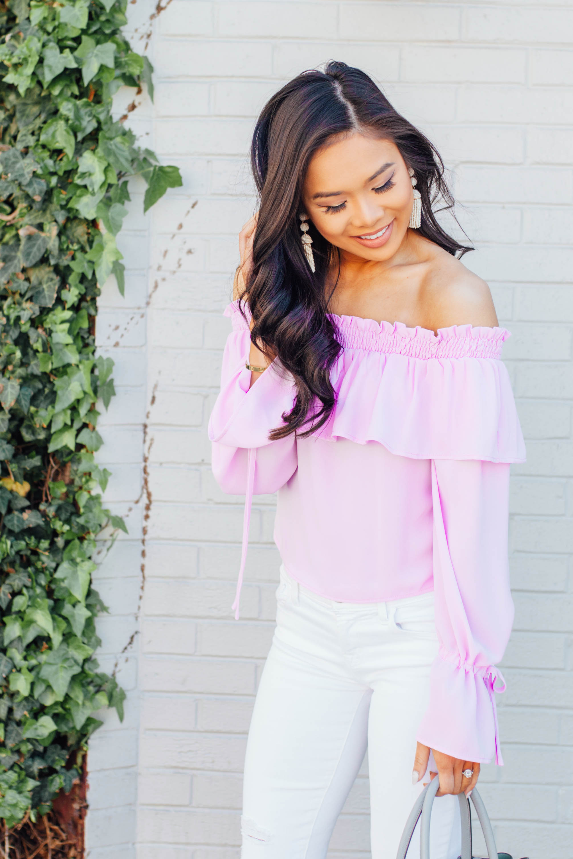 Hoang-Kim wears a lavender off-the-shoulder top with white jeans and wedges for spring