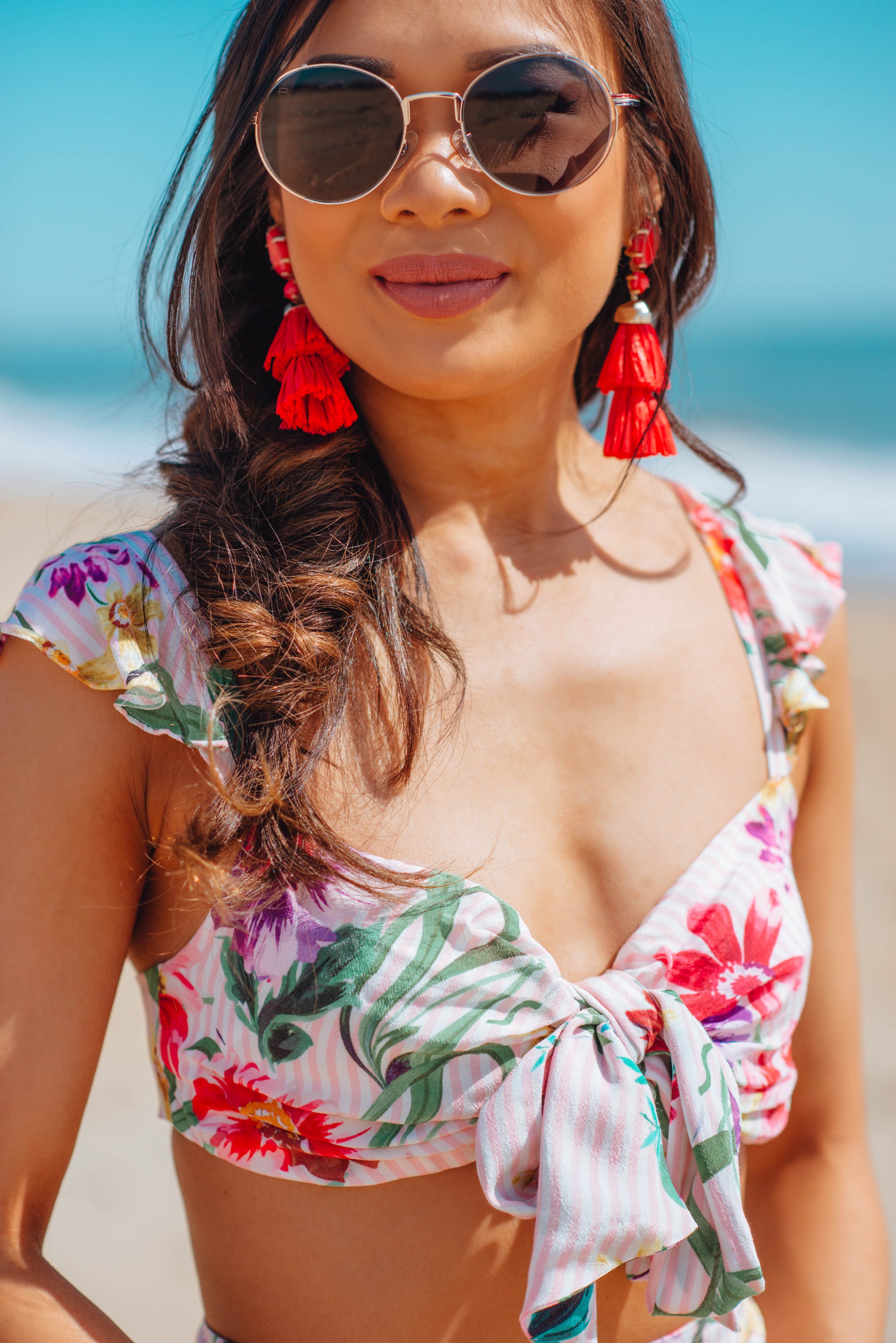 Blogger Hoang-Kim wears a floral two piece set with tassel earrings and a fishtail braid for the beach