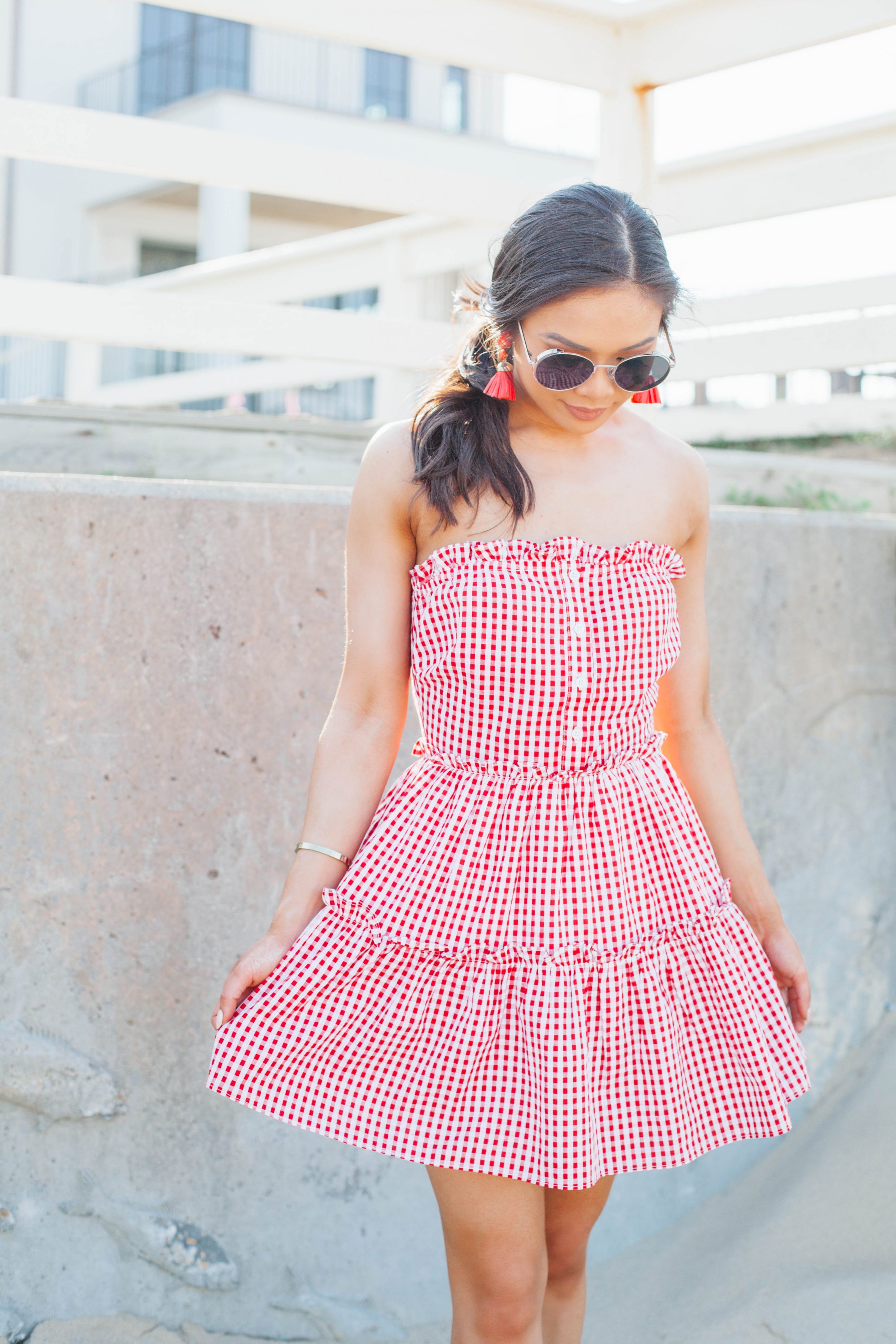 Hoang-Kim wears a red strapless gingham dress with raffia tassel earrings for summer