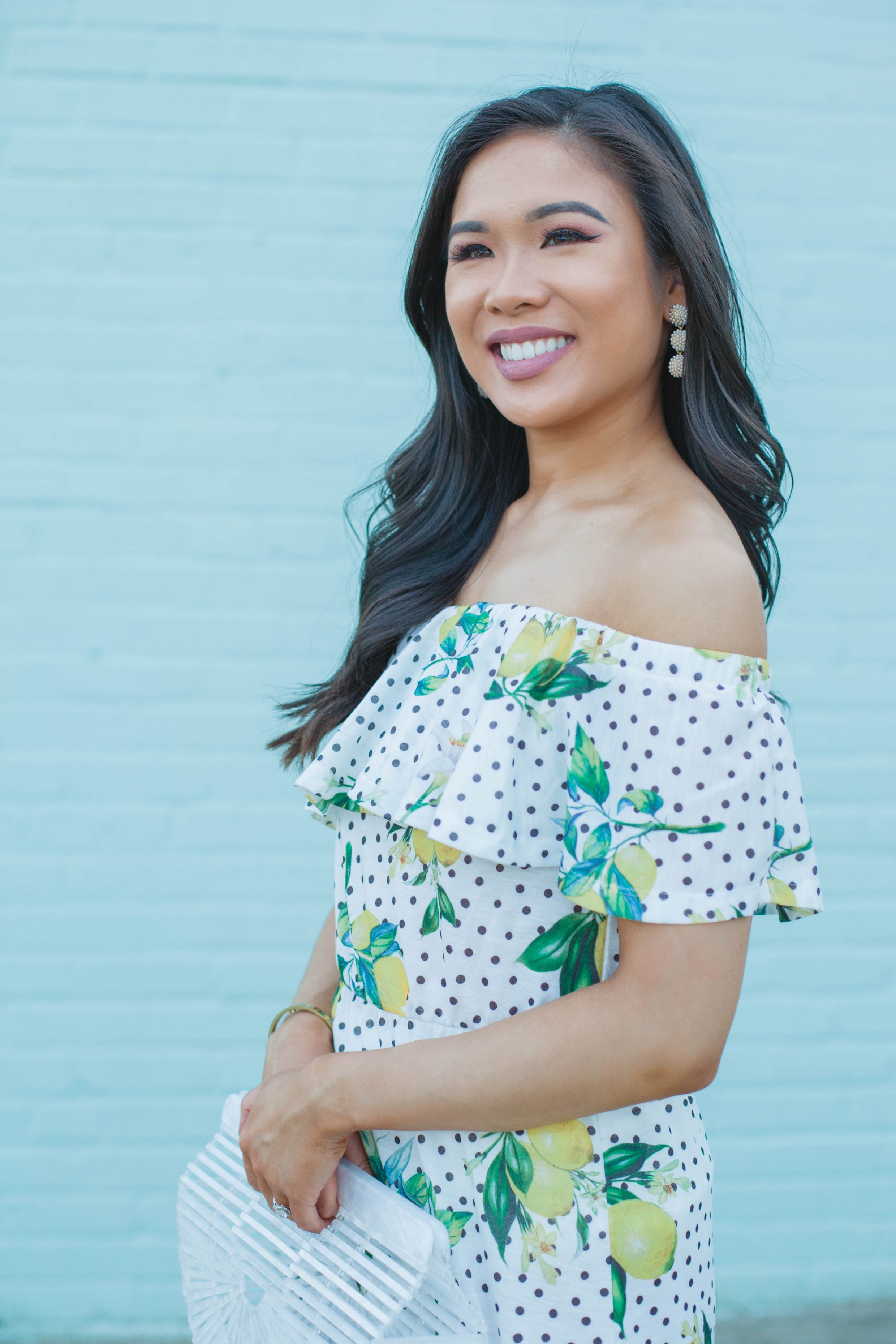 Hoang-Kim wears an off the shoulder lemon print dress with olive + piper pearl drop earrings