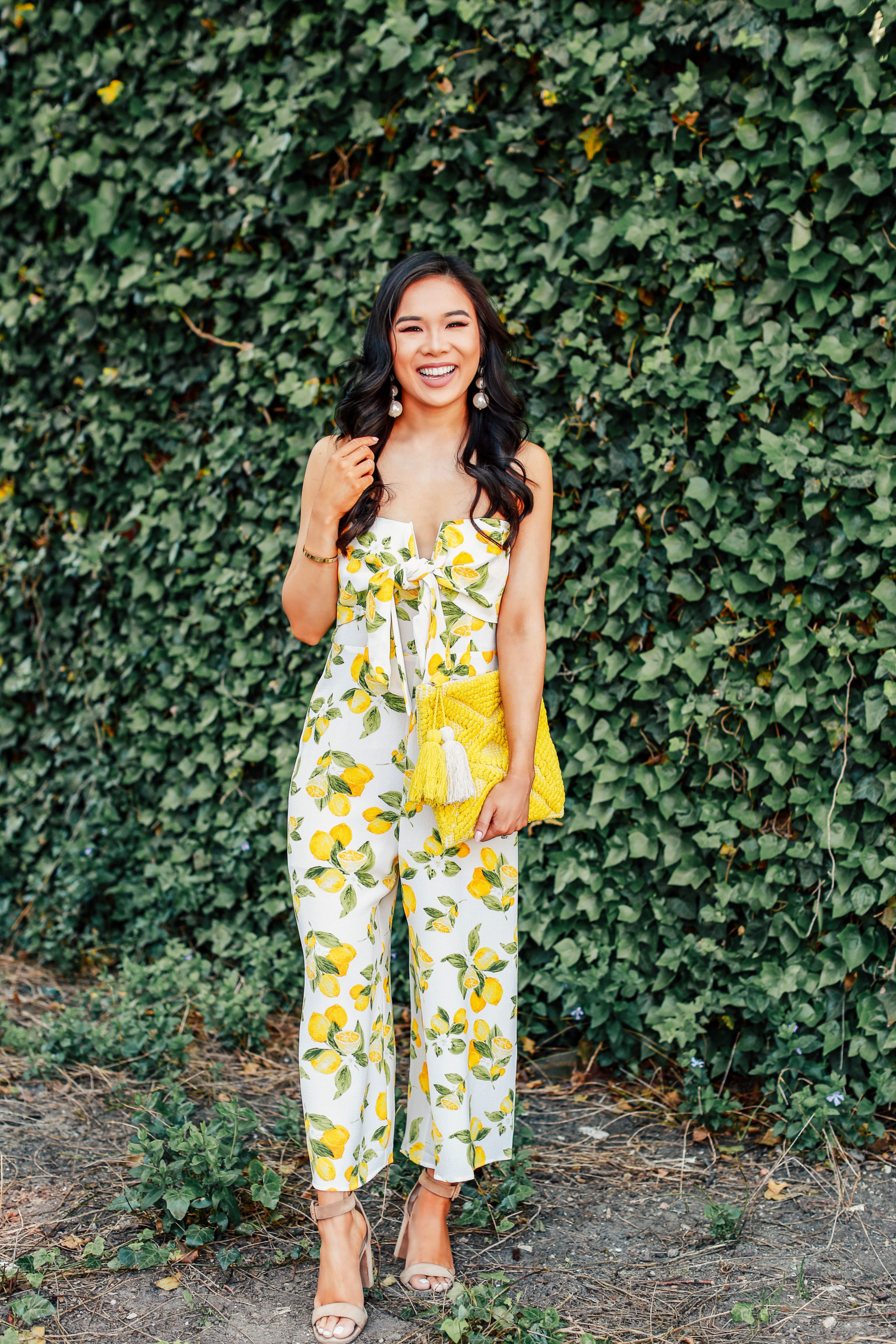 Hoang-Kim wears a strapless lemon print jumpsuit with a yellow Palisades clutch