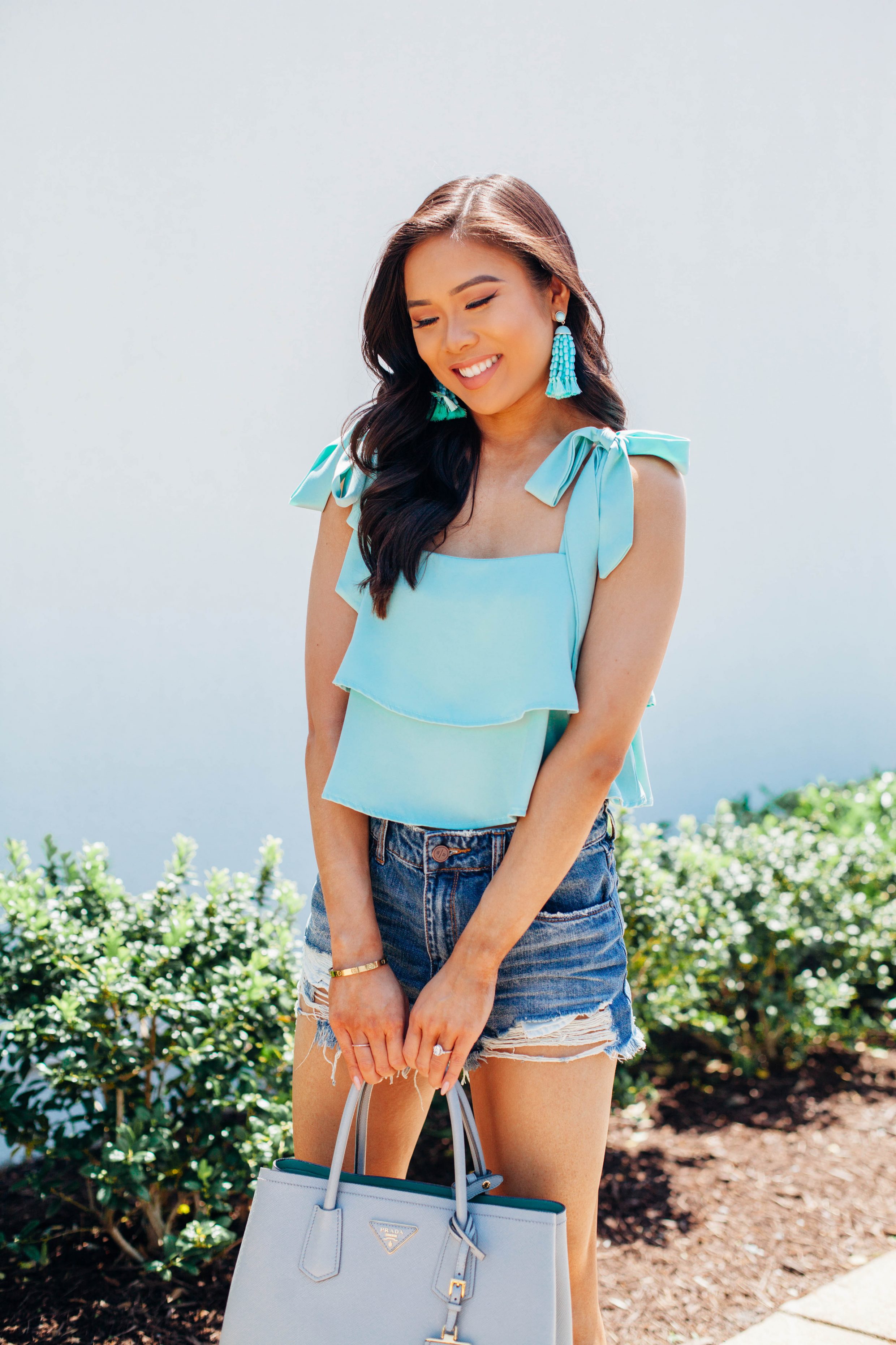 Mint ruffle crop top with distressed shorts and tassel earrings