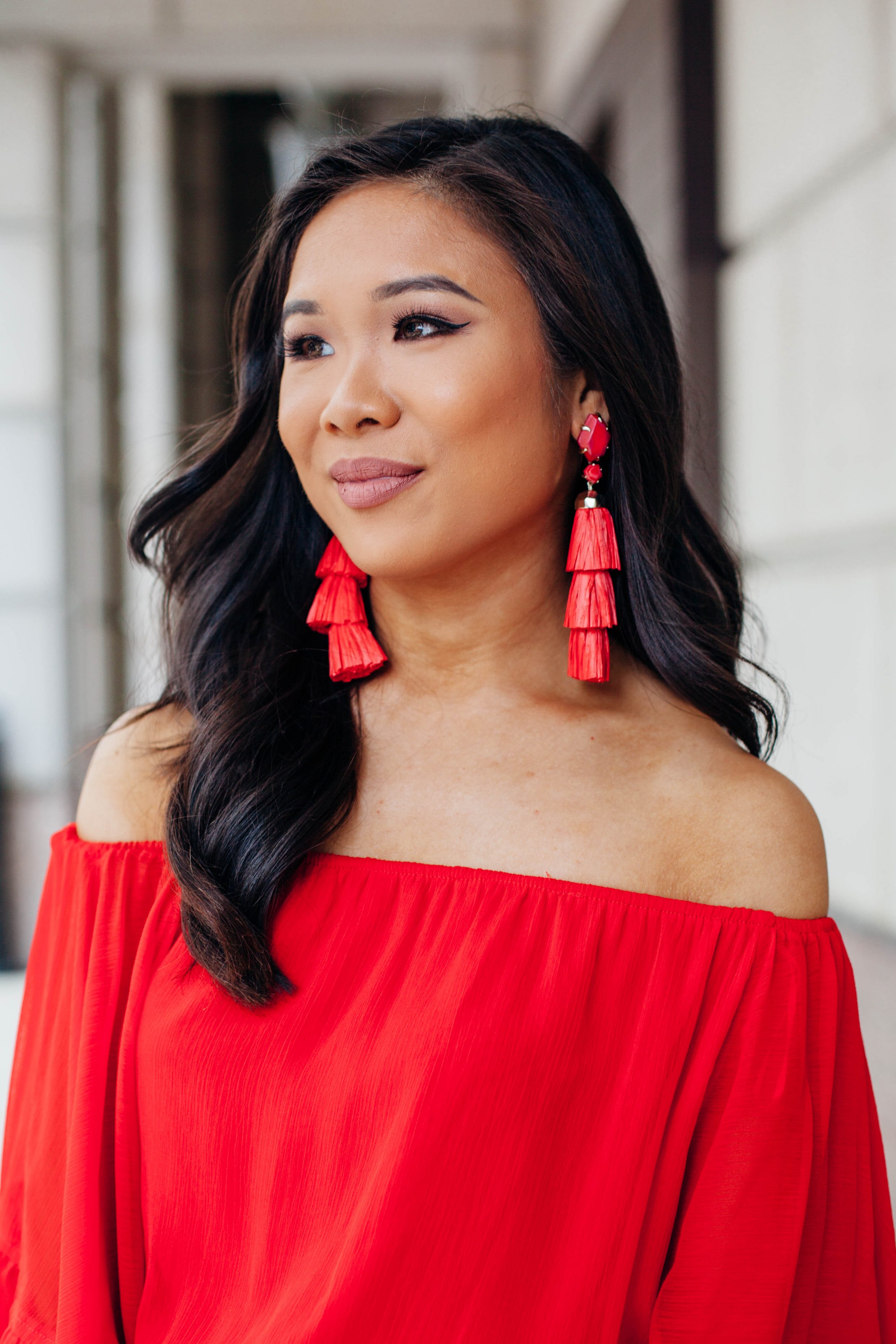 Hoang-Kim wears Kendra Scott Denise tassel earrings with a red off the shoulder romper