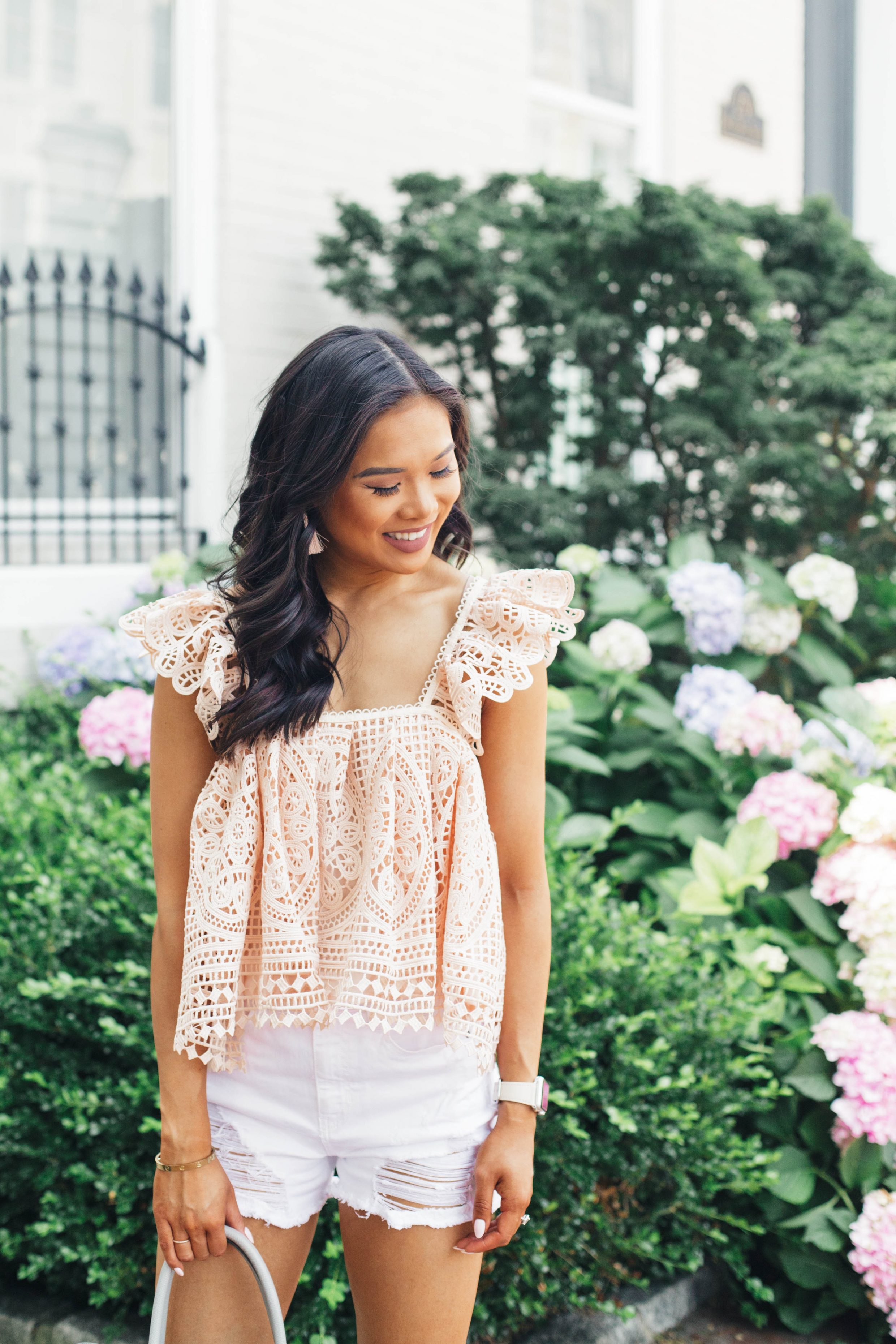 Blogger Hoang-Kim wears a pink crochet cropped top and white distressed shorts for summer