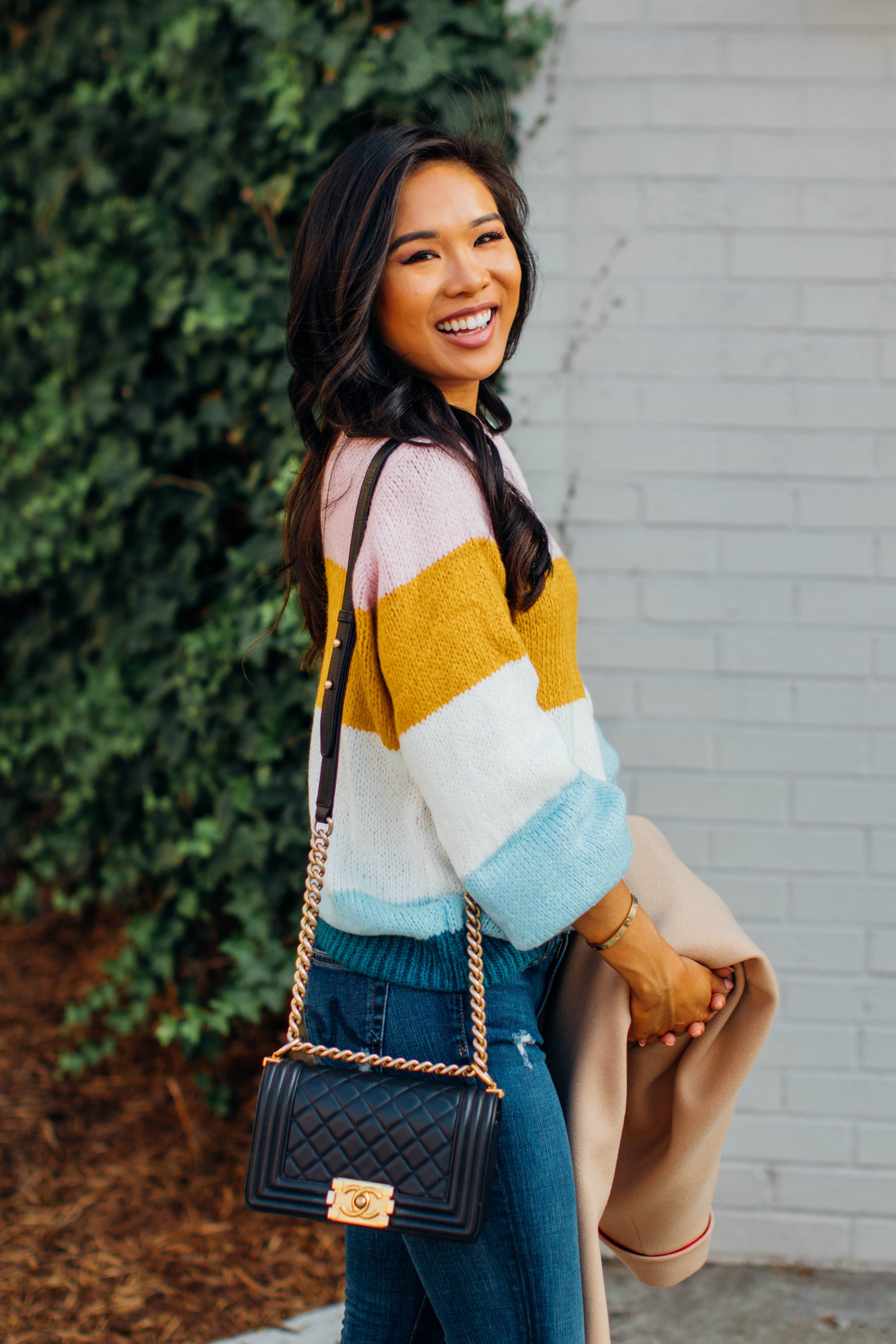 Blogger Hoang-Kim wears a striped transition sweater with a Chanel bag for fall