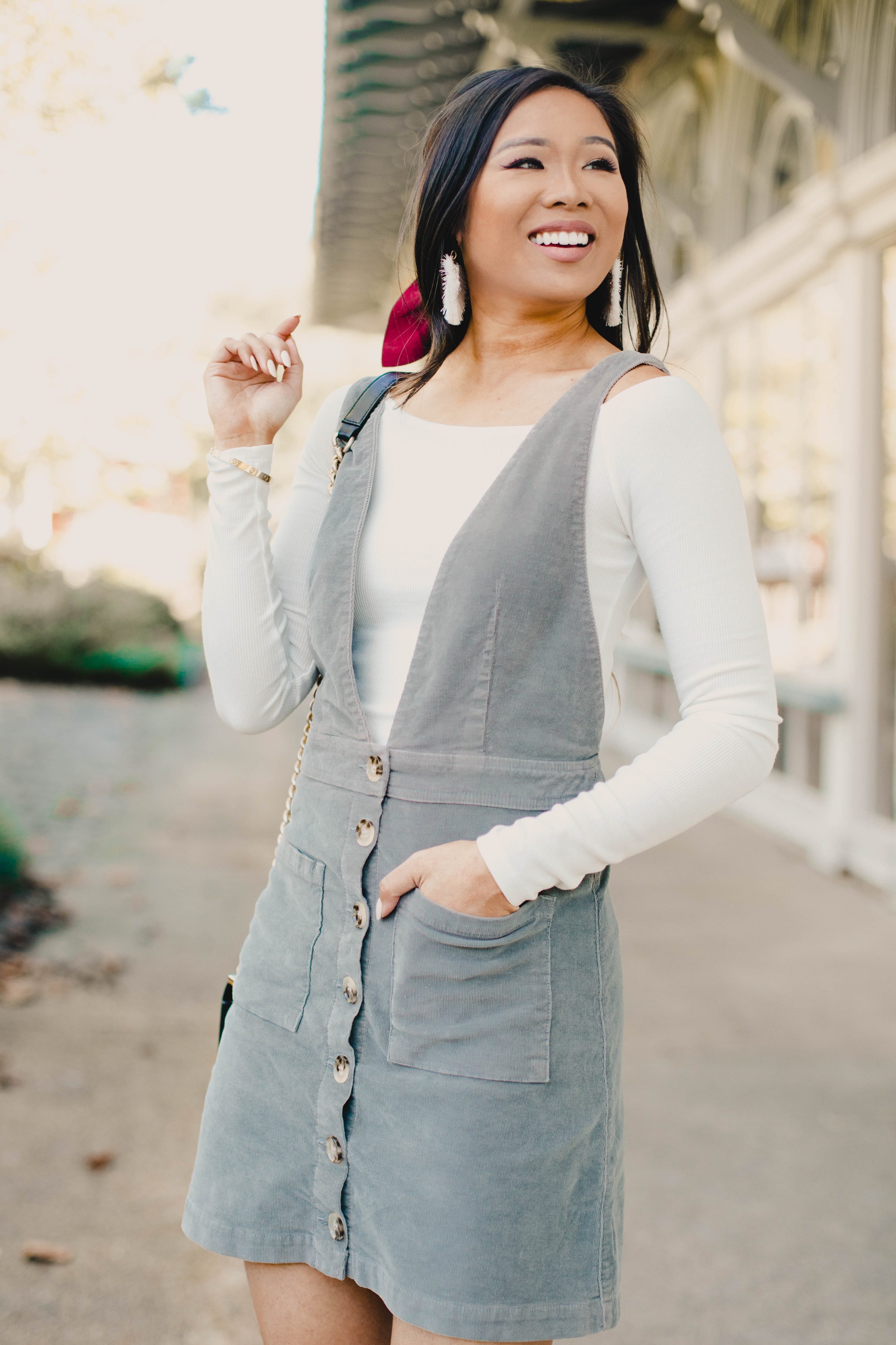 Blogger Hoang-Kim wears a corduroy overall dress with a satin scrunchie for fall