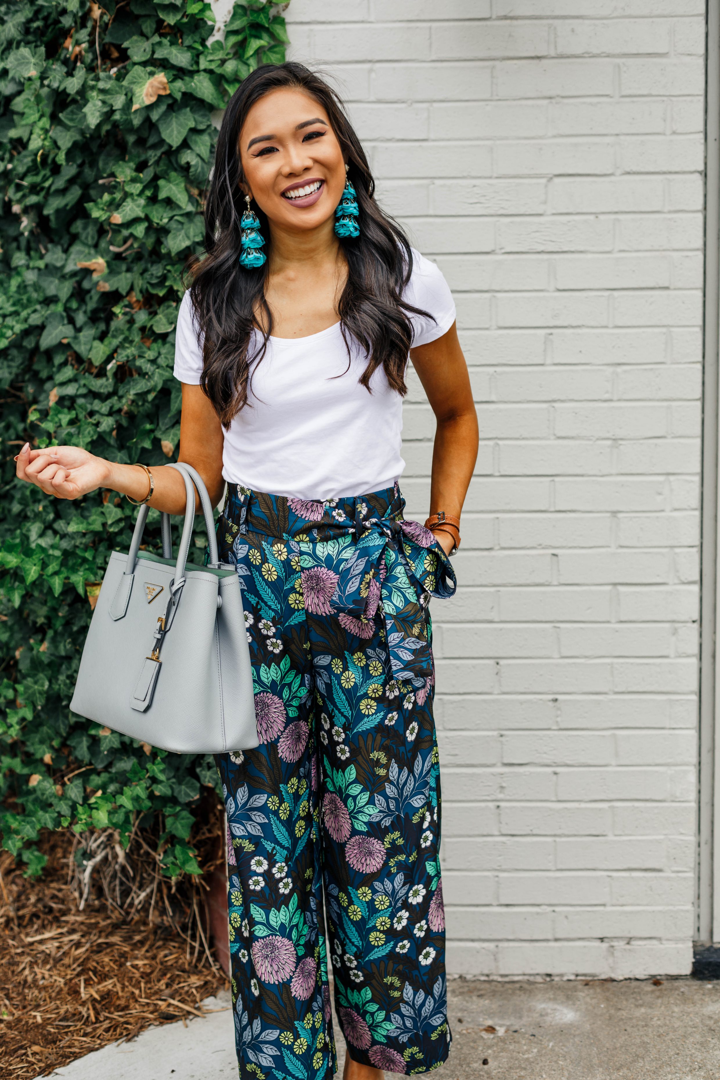 Blogger Hoang-Kim styles a pair of silk wide-leg pants with teal feather earrings