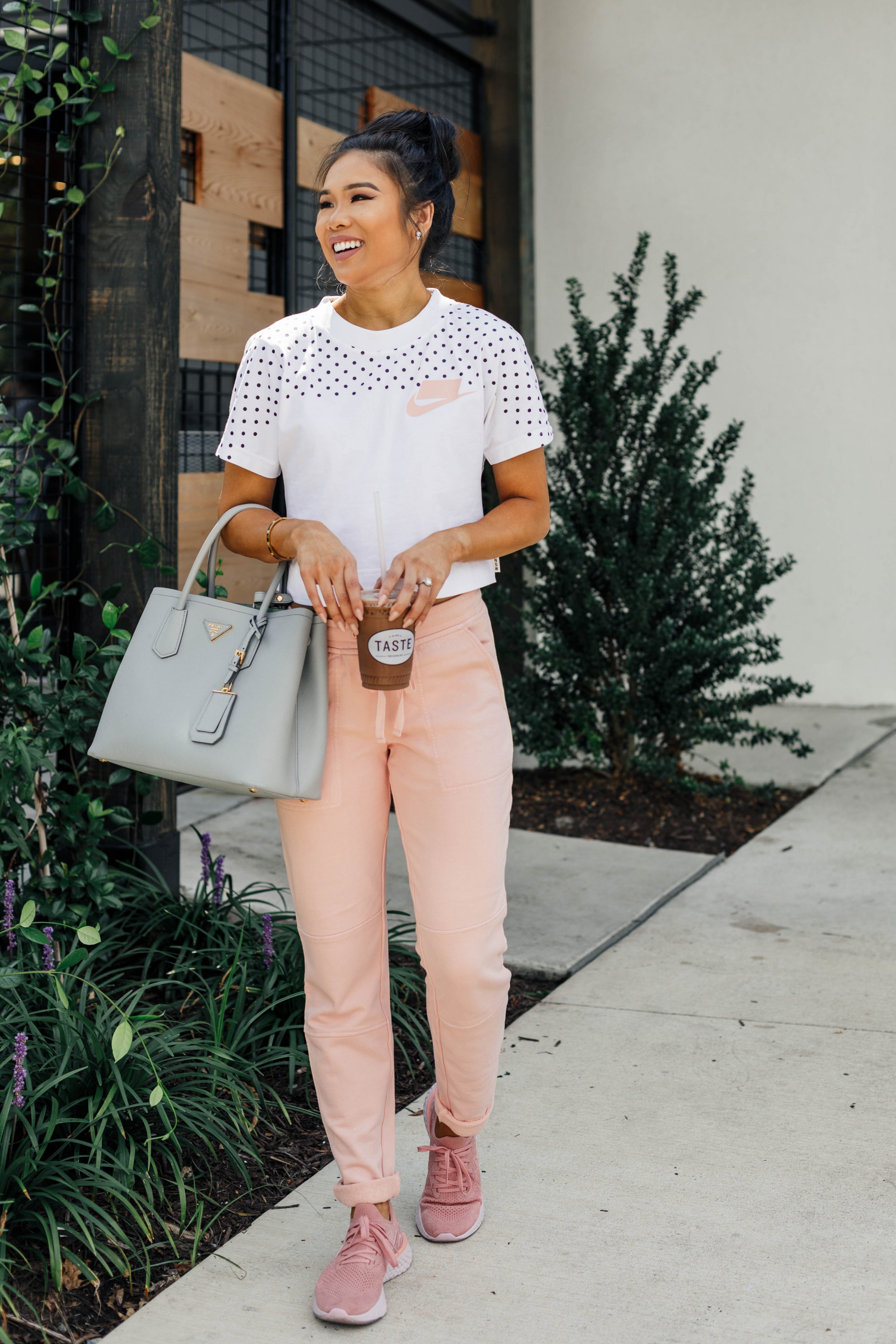 Blogger Hoang-Kim in athleisure wearing a Nike crop tee, sneakers and pink joggers