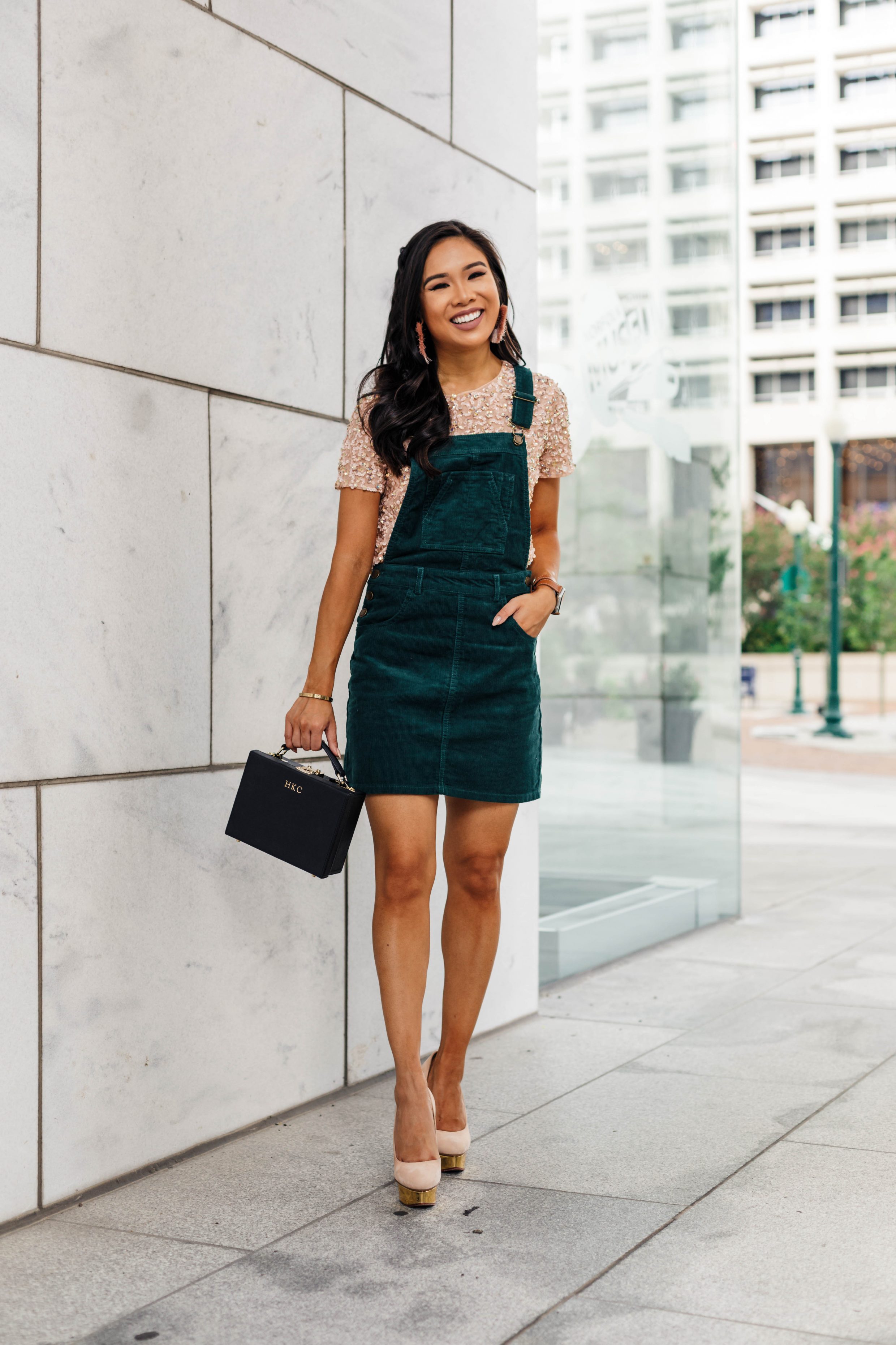 Hoang-Kim wears a green corduroy overall dress with a blush sequin t-shirt for fall