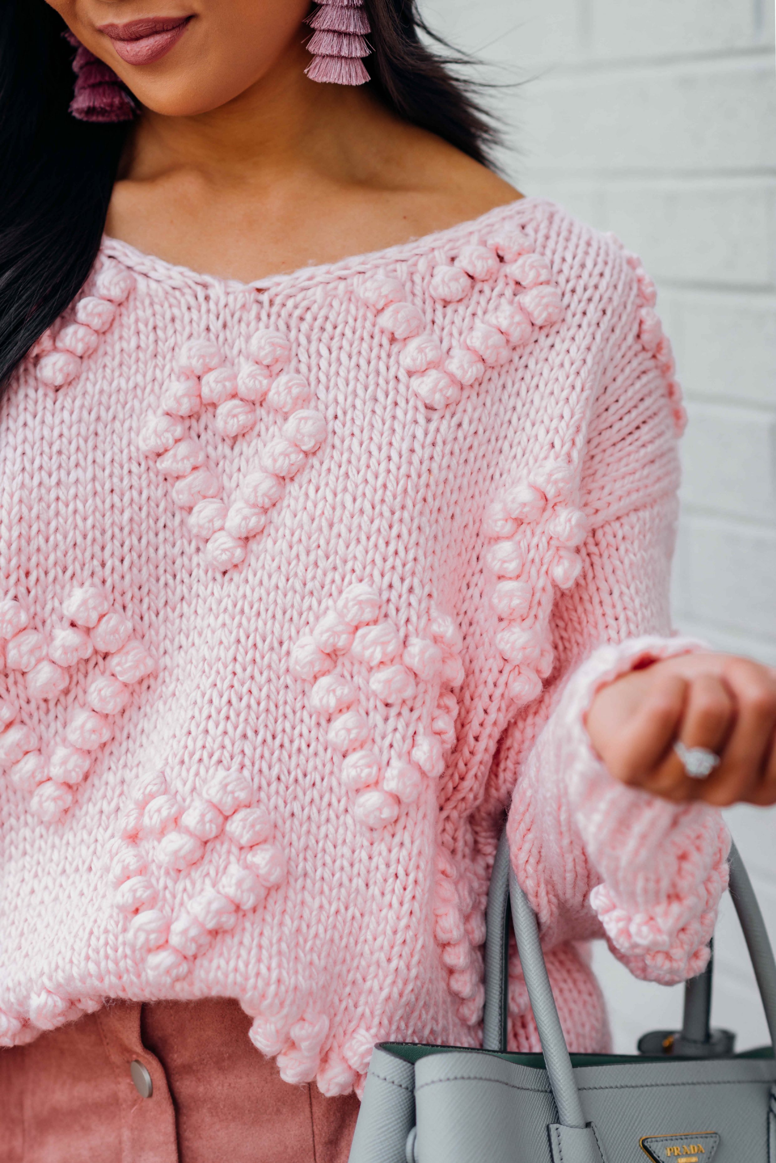 Blogger Hoang-Kim wears a pink sweater with heart pom poms