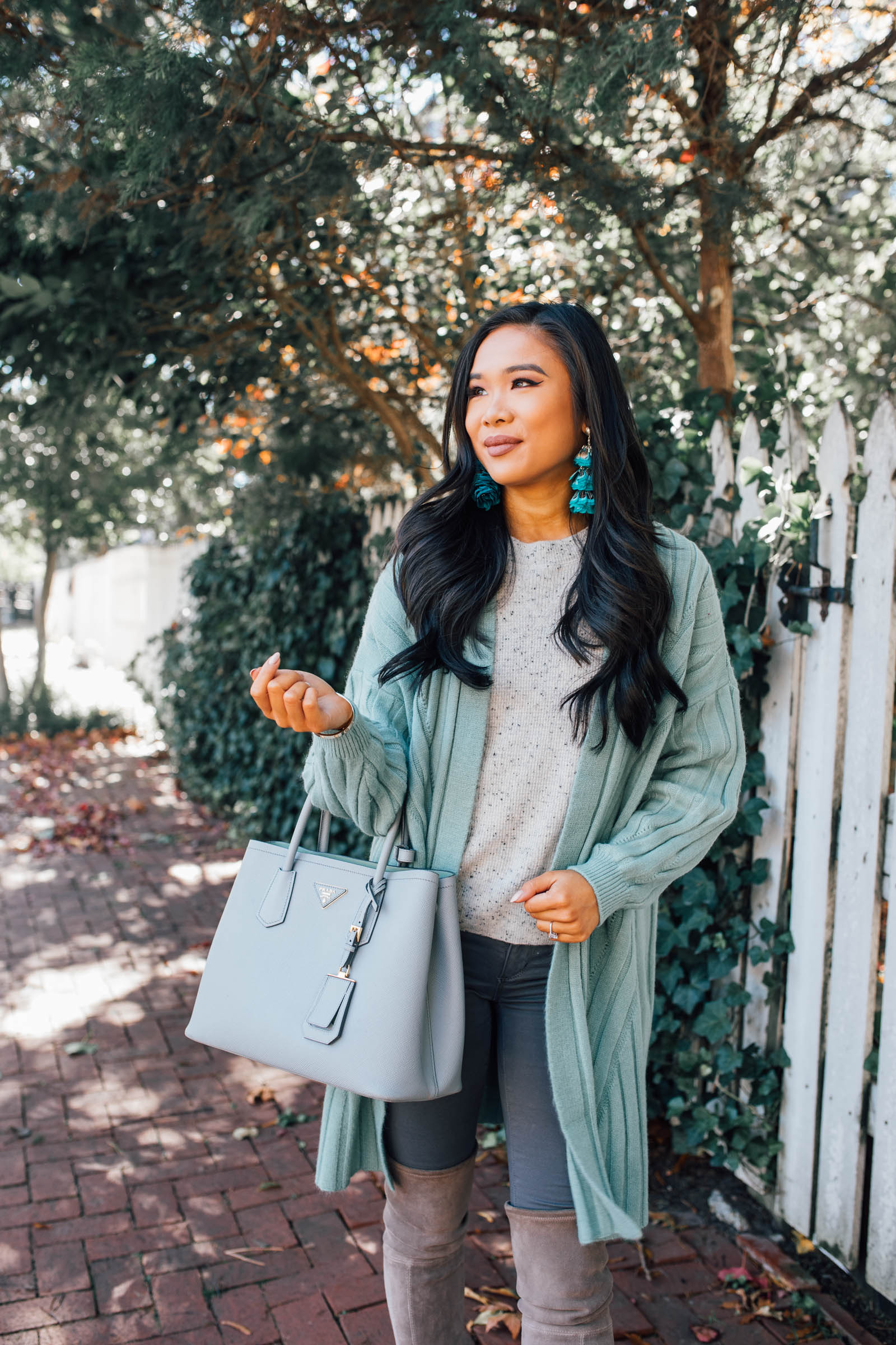 Blogger Hoang-Kim wears a mint green cardigan from Chicwish with Kendra Scott Lenni Gold Feather earrings
