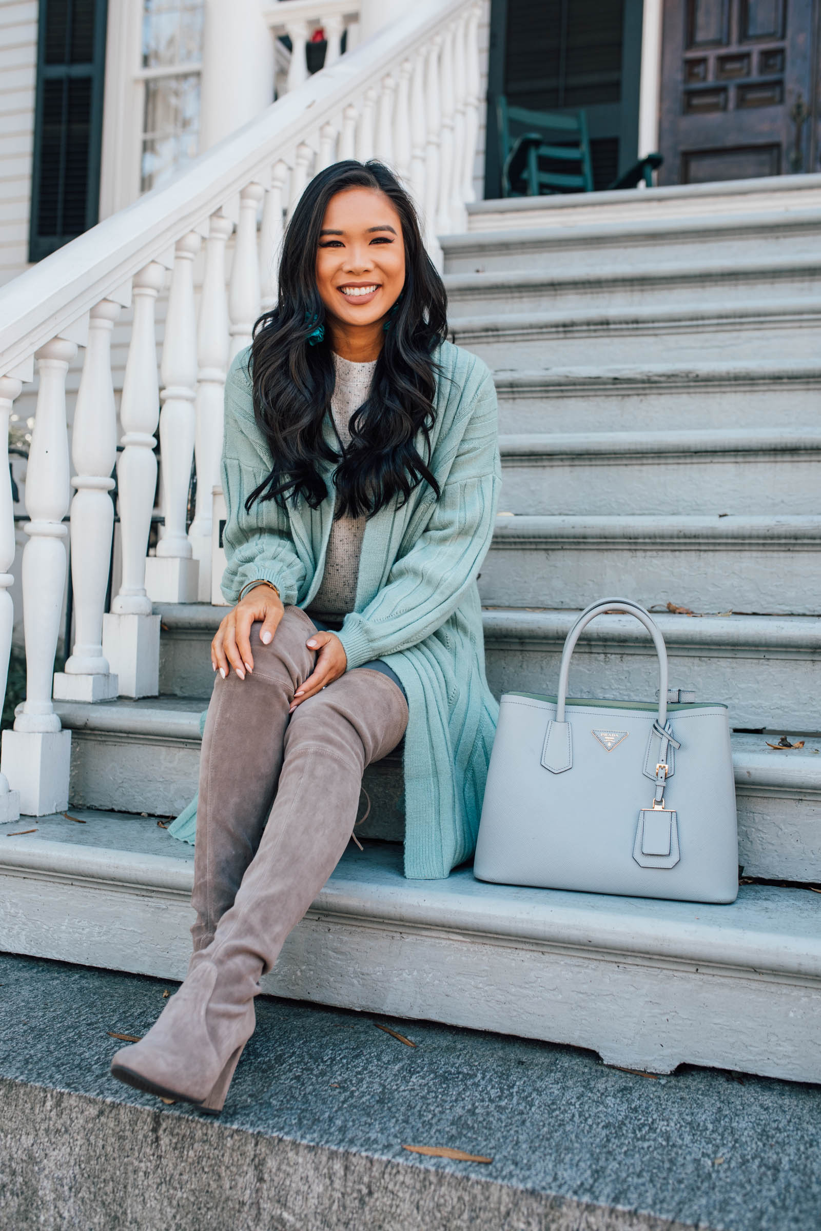 Blogger Hoang-Kim wears a mint green cardigan and over-the-knee boots for a fall ottd