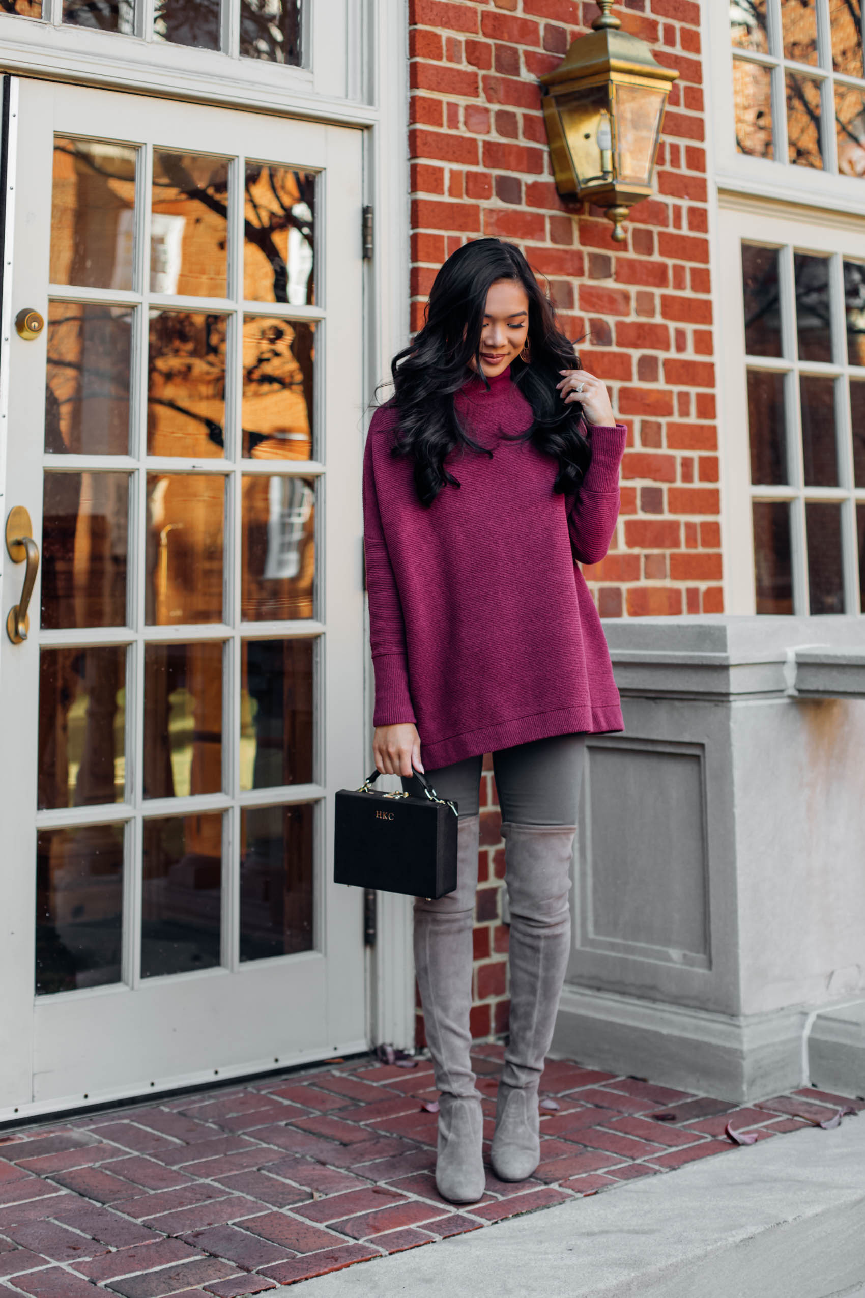 Blogger Hoang-Kim wears a oversized tunic sweater with over the knee boots
