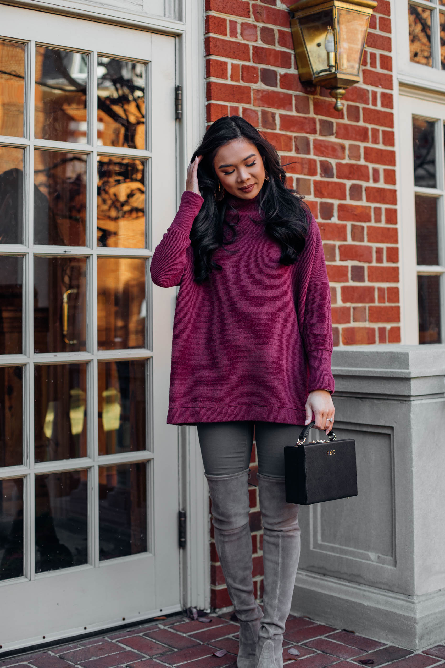Blogger Hoang-Kim wears a oversized tunic sweater with gray over the knee boots and a black box bag