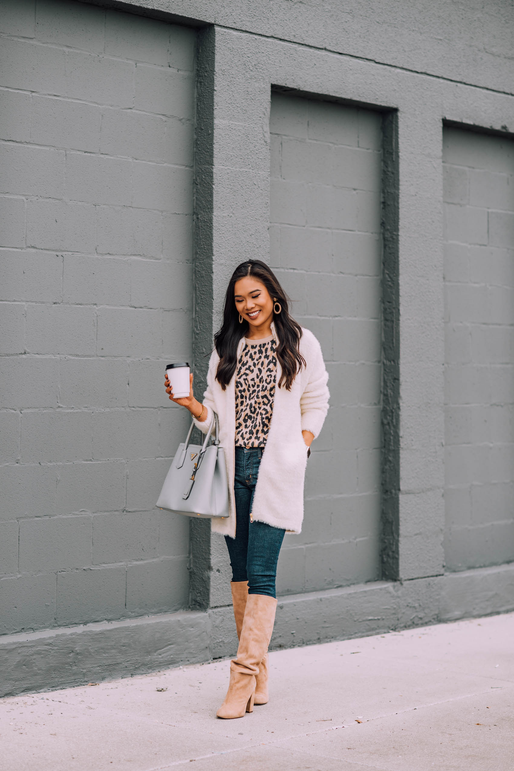 Blogger Hoang-Kim wears a chunky oversized sweater with knee high boots