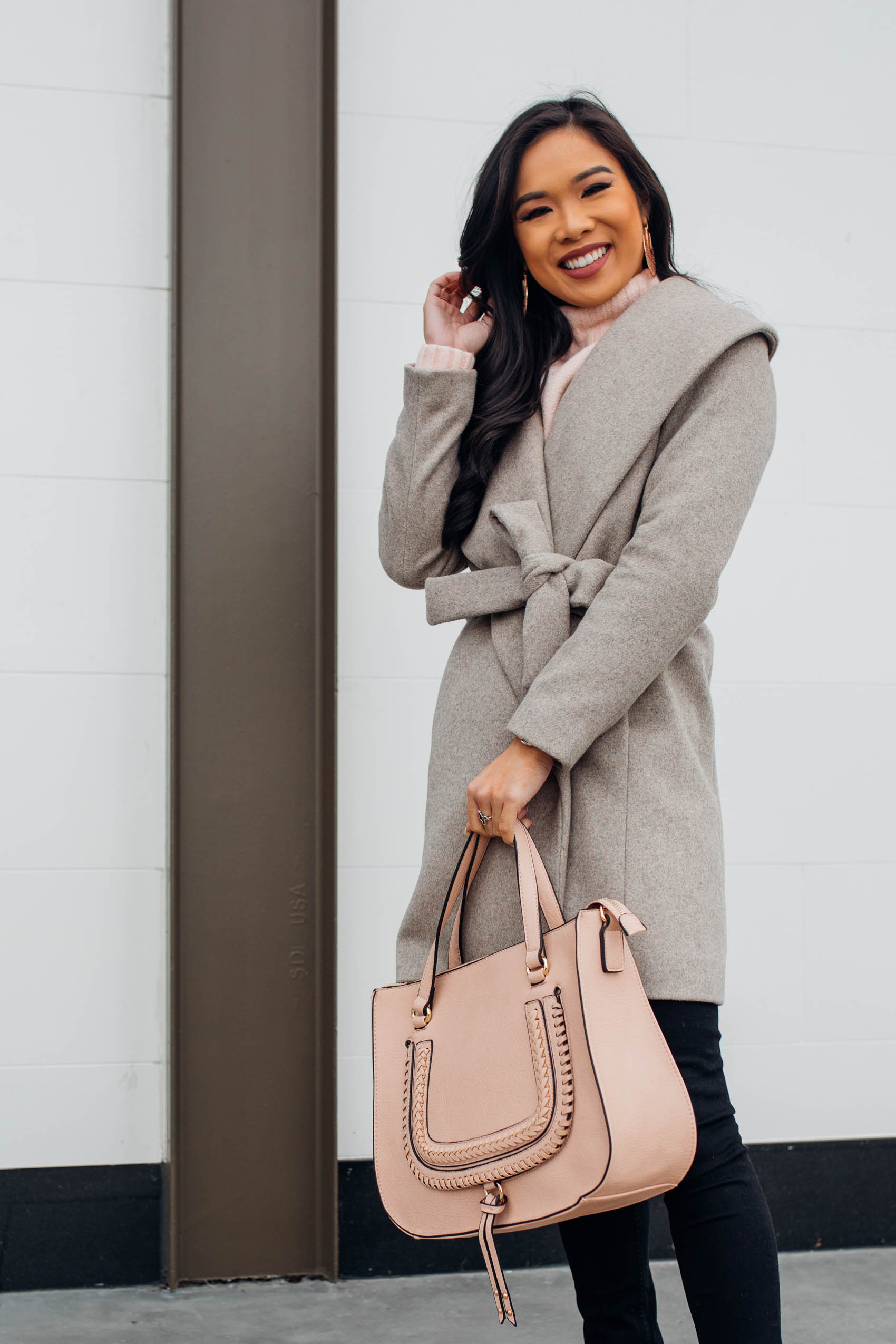 Blogger Hoang-Kim shares a winter outfit idea with a wool wrap coat and blush handbag
