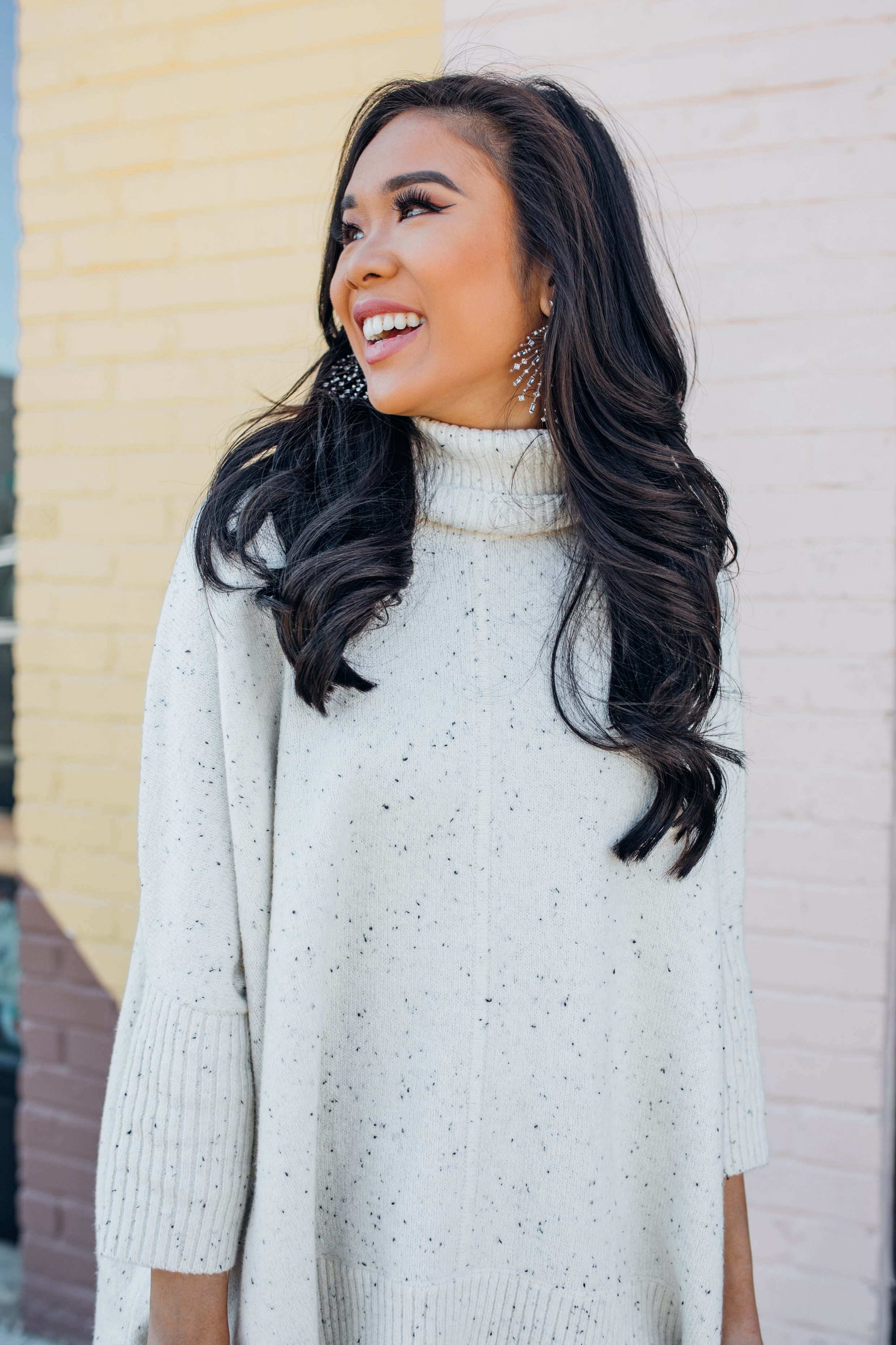 Blogger Hoang-Kim shares a casual winter outfit with a turtleneck poncho and Kendra Scott earrings