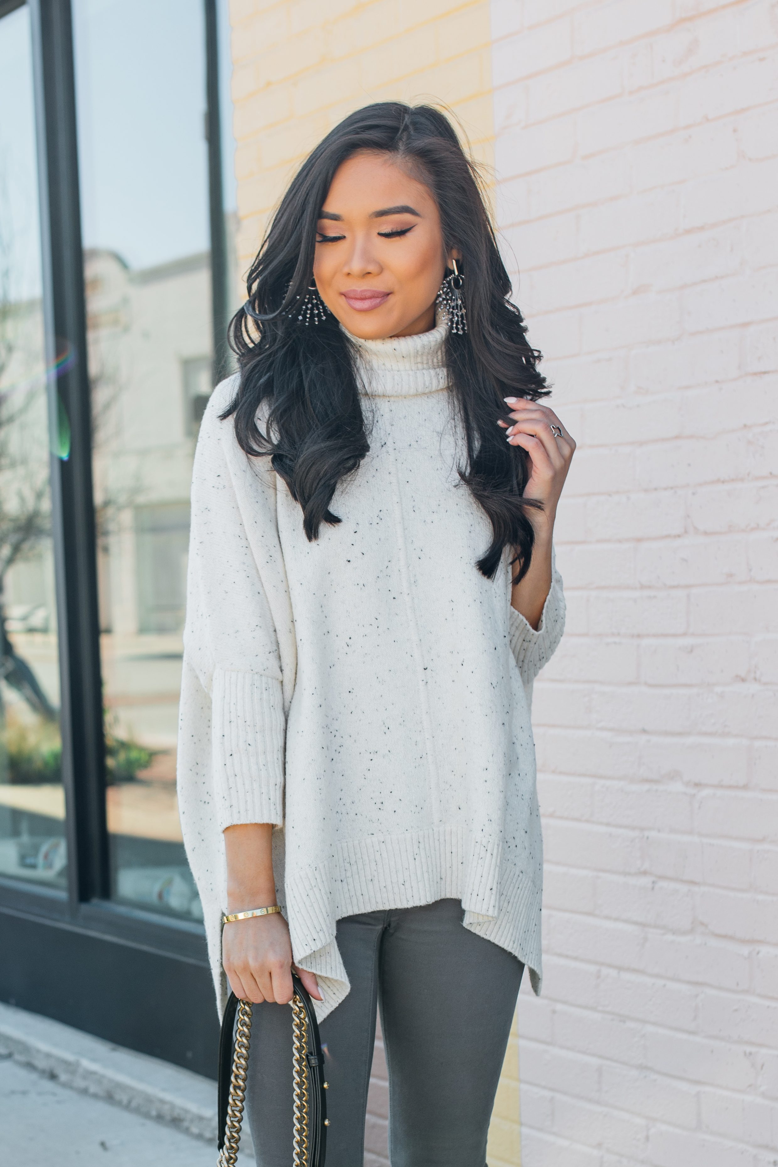 Blogger Hoang-Kim shares a casual winter outfit with a loft turtleneck poncho