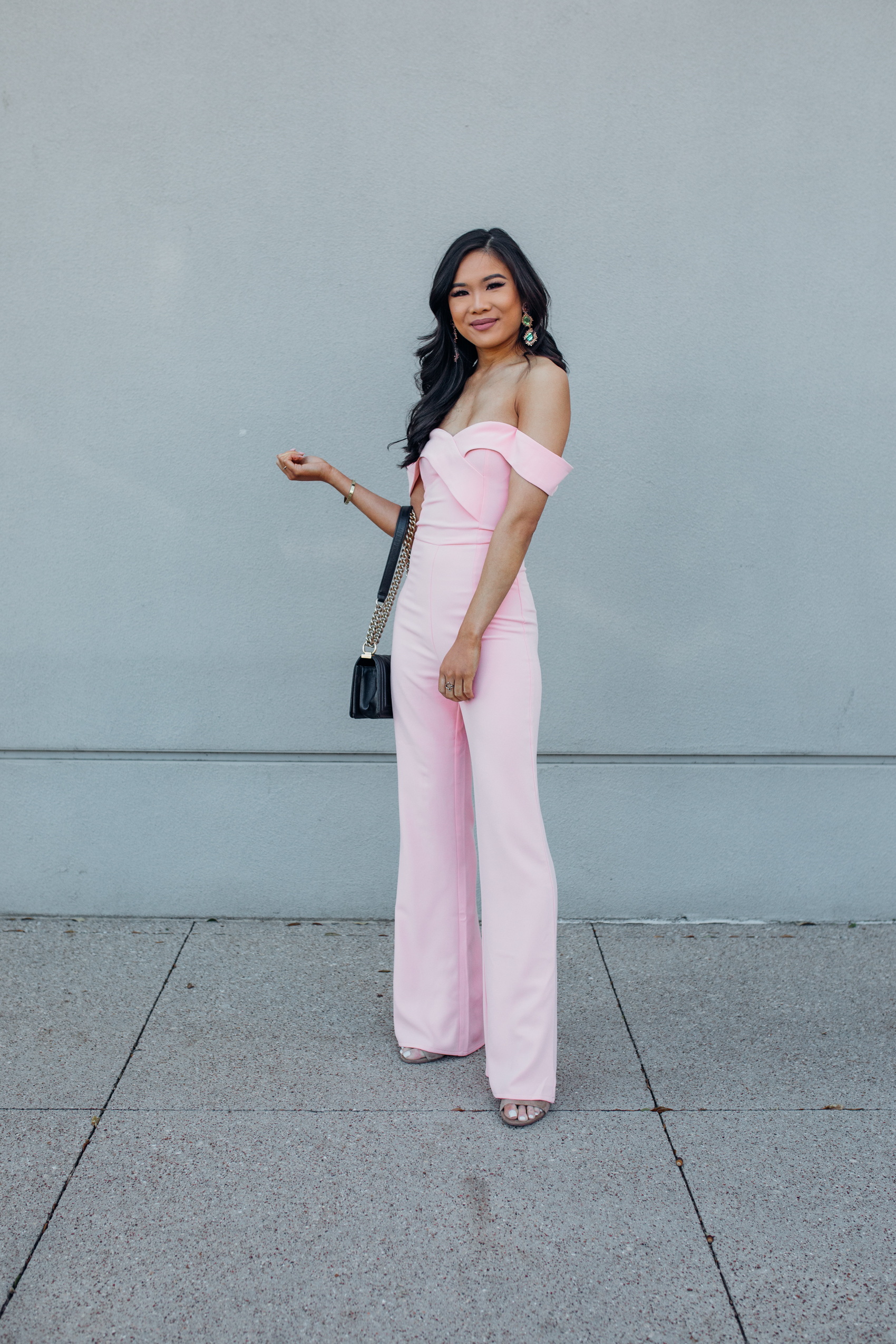 Asian woman wearing a blush off the shoulder blush jumpsuit