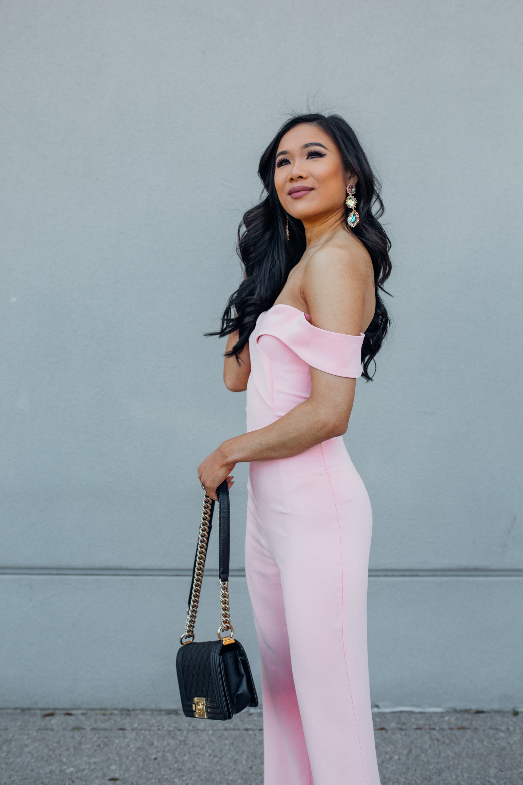 Asian woman wearing a blush off the shoulder blush jumpsuit