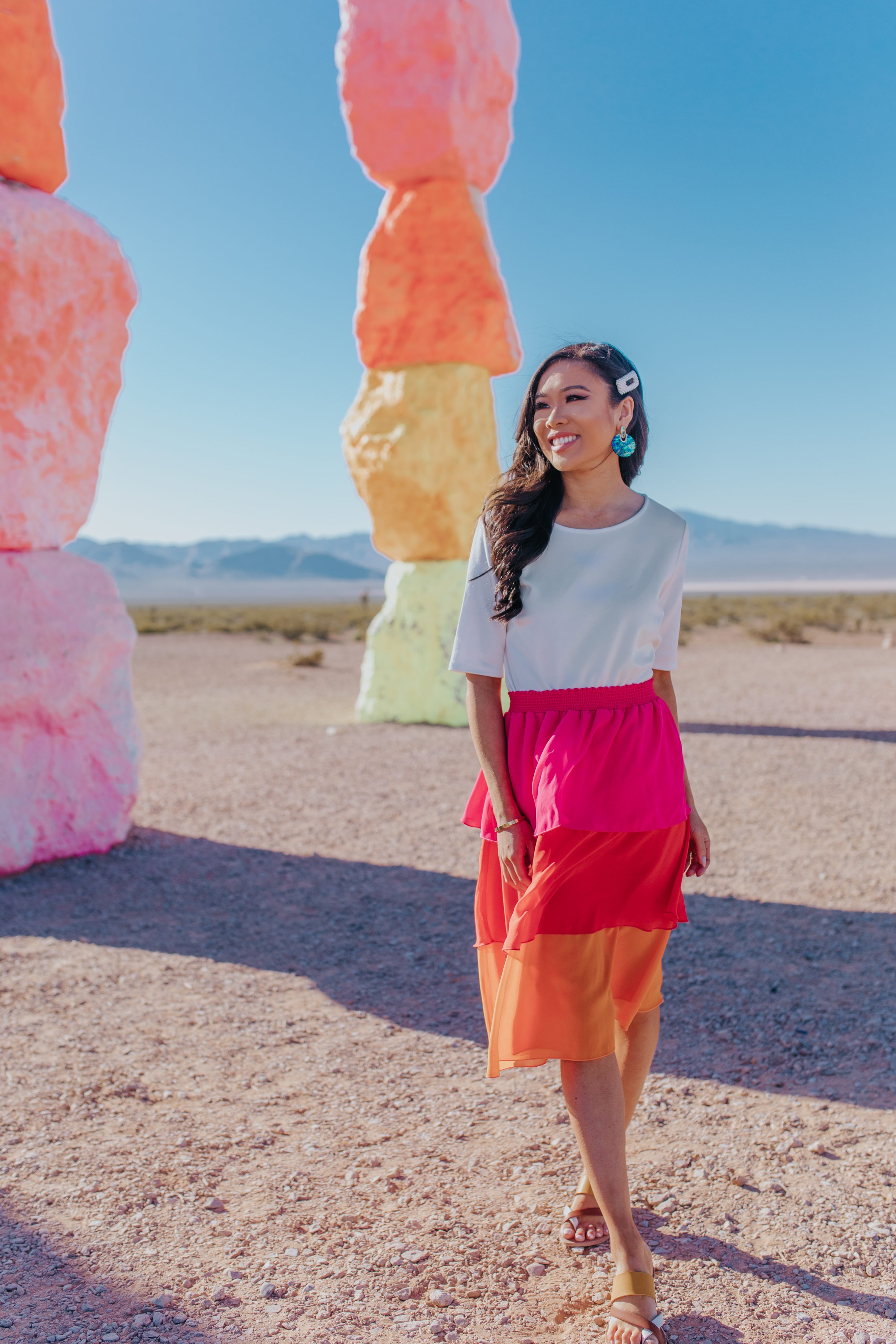 Hoang-Kim wears a white tee, colorful skirt and Dolce Vita Sandals at Seven Magic Mountains