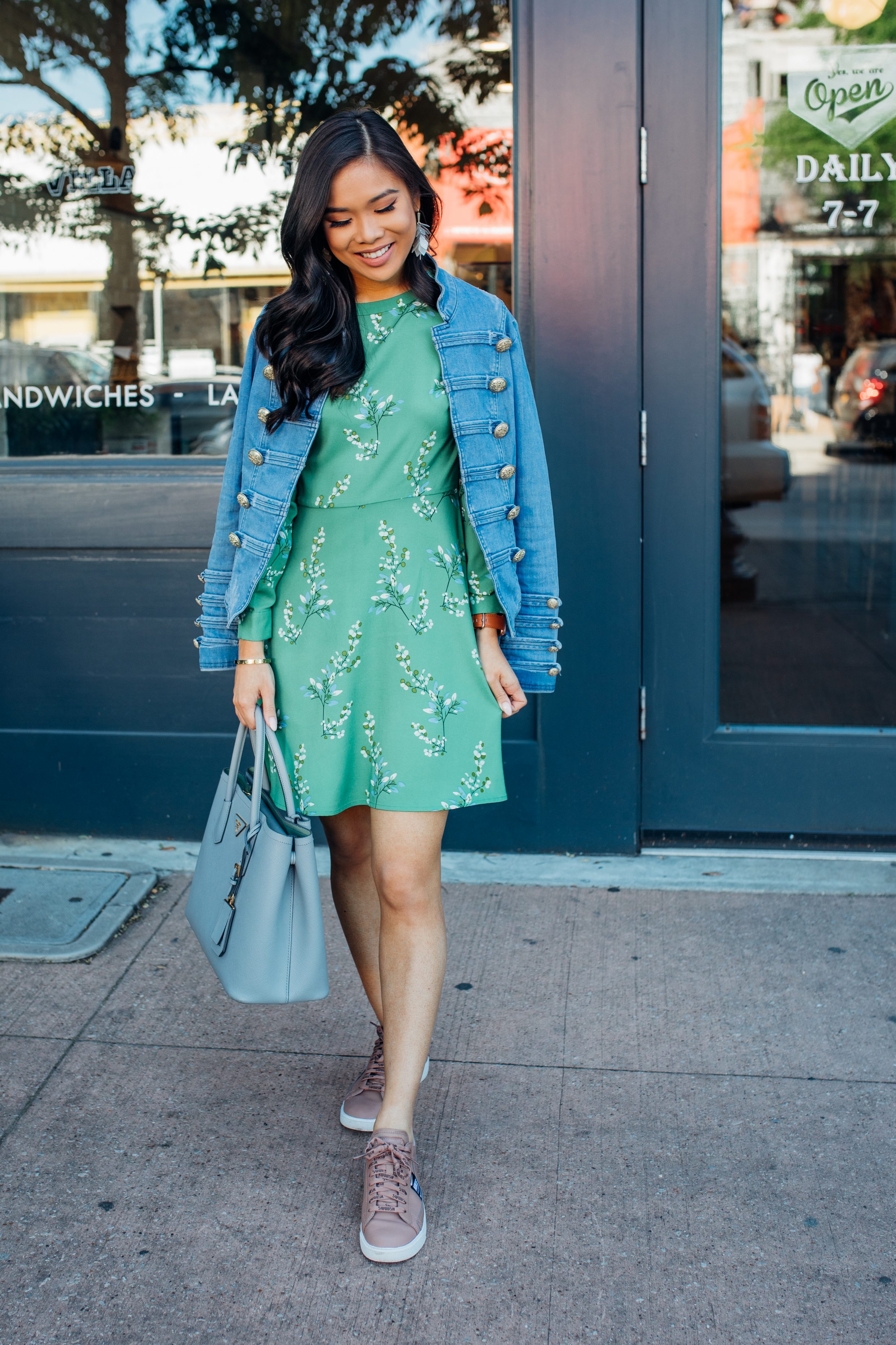 Blogger Hoang-Kim wears a floral dress with Nike sneakers and a denim jacker