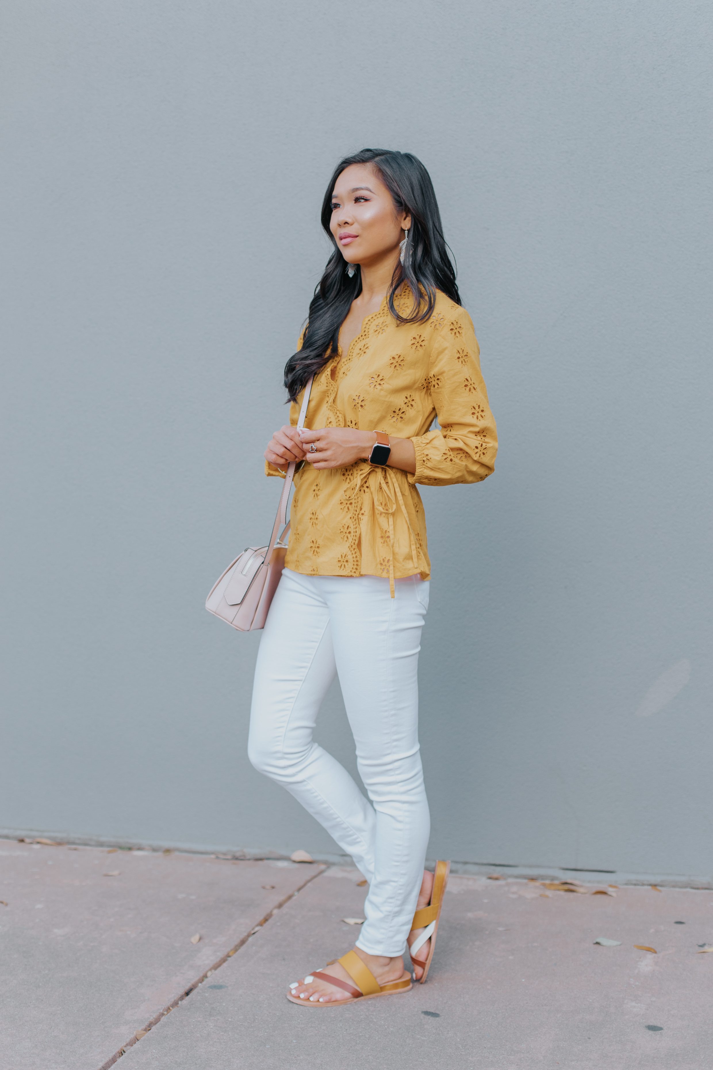 Blogger Hoang-Kim wears a gold Madewell Eyelet Blouse with white jeans