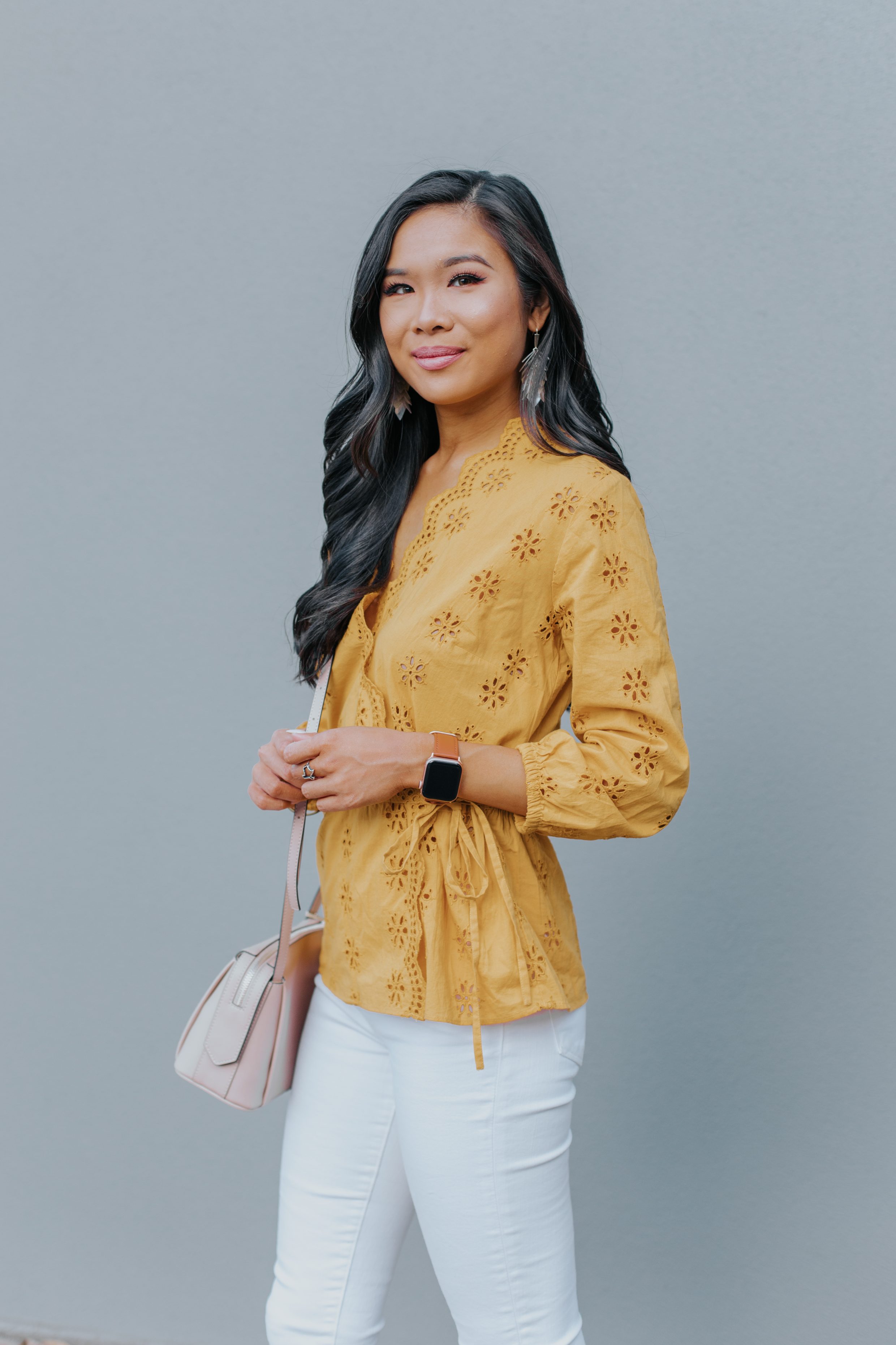 Asian woman wears a gold eyelet blouse