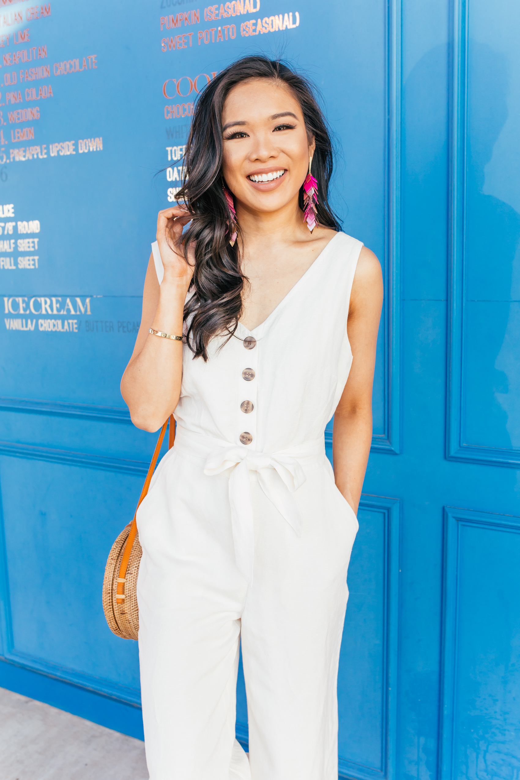 Blogger Hoang-Kim wears a linen tie-waist jumpsuit for summer with Kendra Scott earrings
