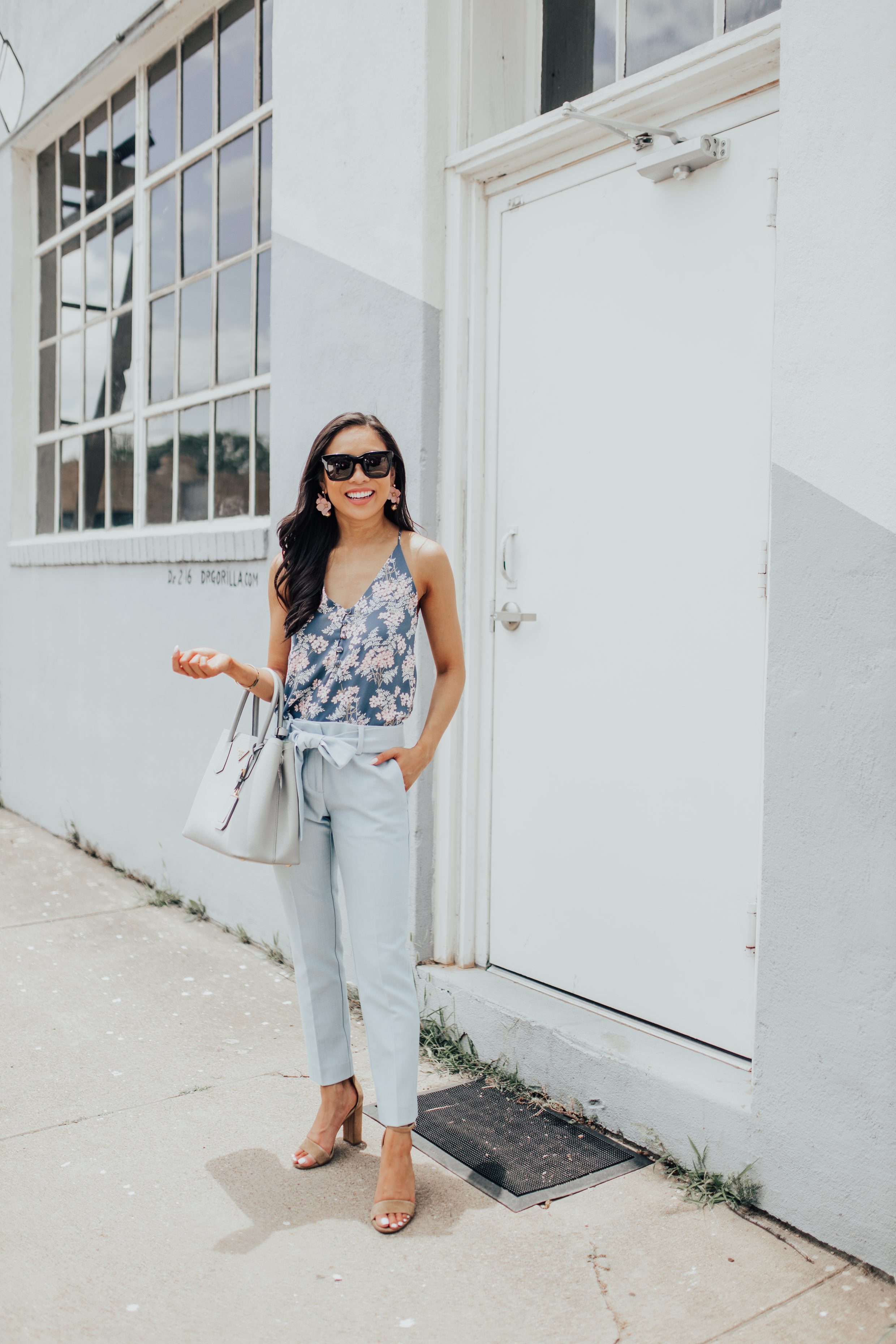 Hoang-Kim wears a floral cami and blue tie waist pants for a business casual workwear look