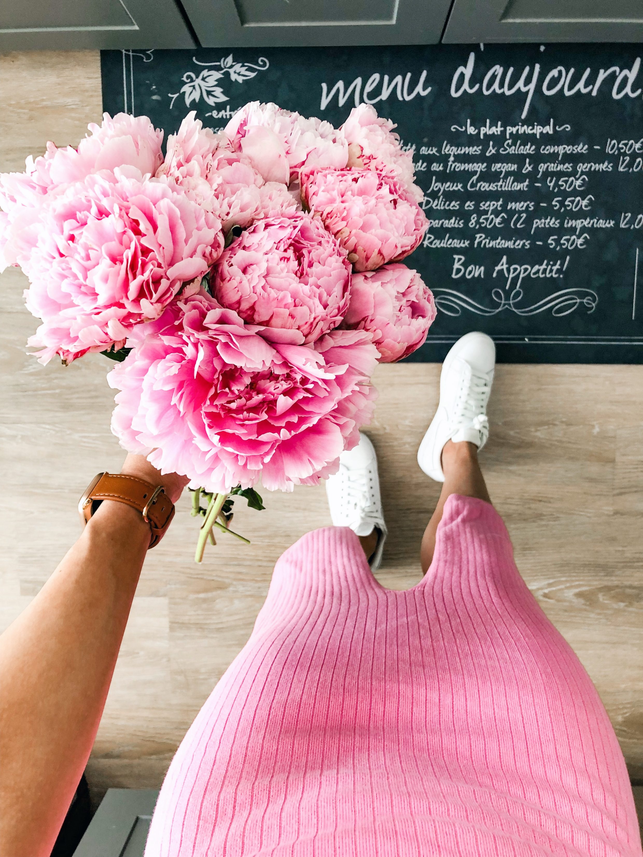Pink peonies bouquet with a pink knit free people skirt and white Nike sneakers
