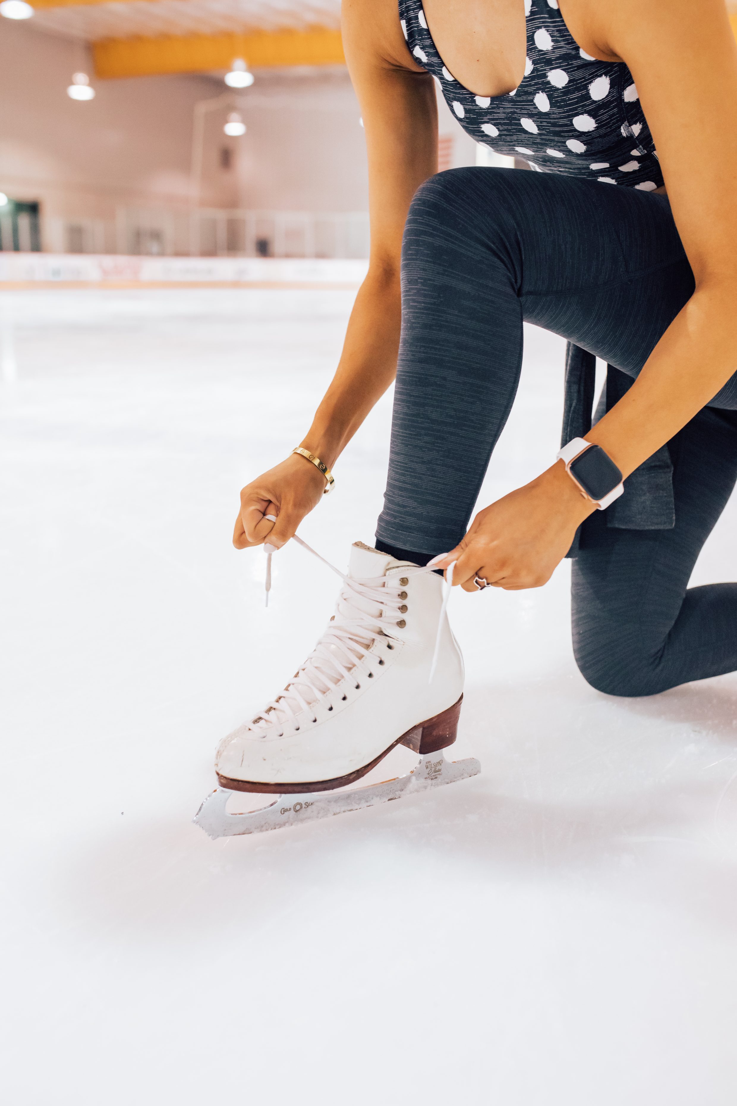 Figure skater ties her Harlick figure skating boots wearing Outdoor Voices tech sweat
