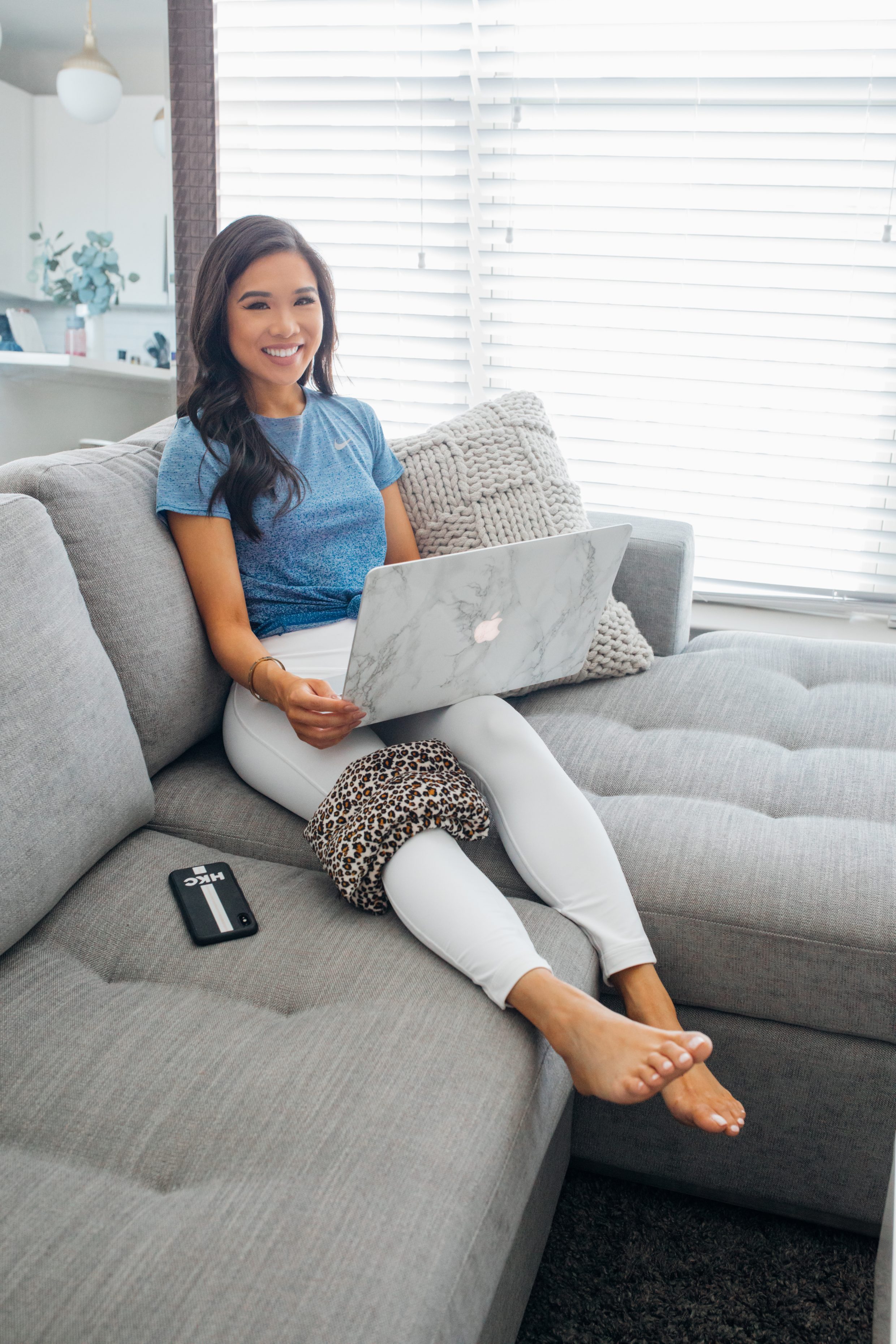 Blogger Hoang-Kim wears a blue and white activewear outfit on an Article sofa