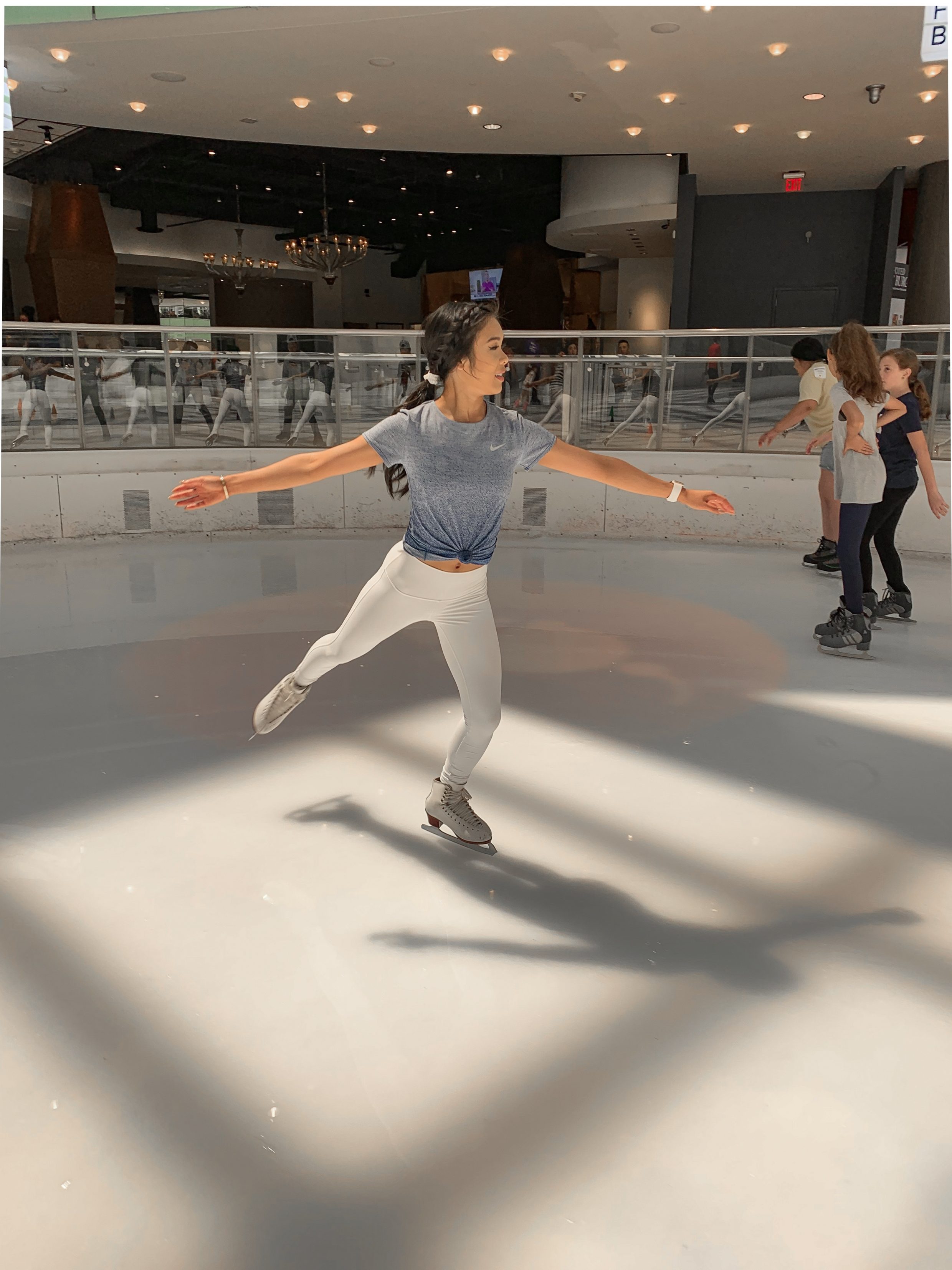 Ice skating outfit featuring blue dri-fit shirt and white high waisted leggings