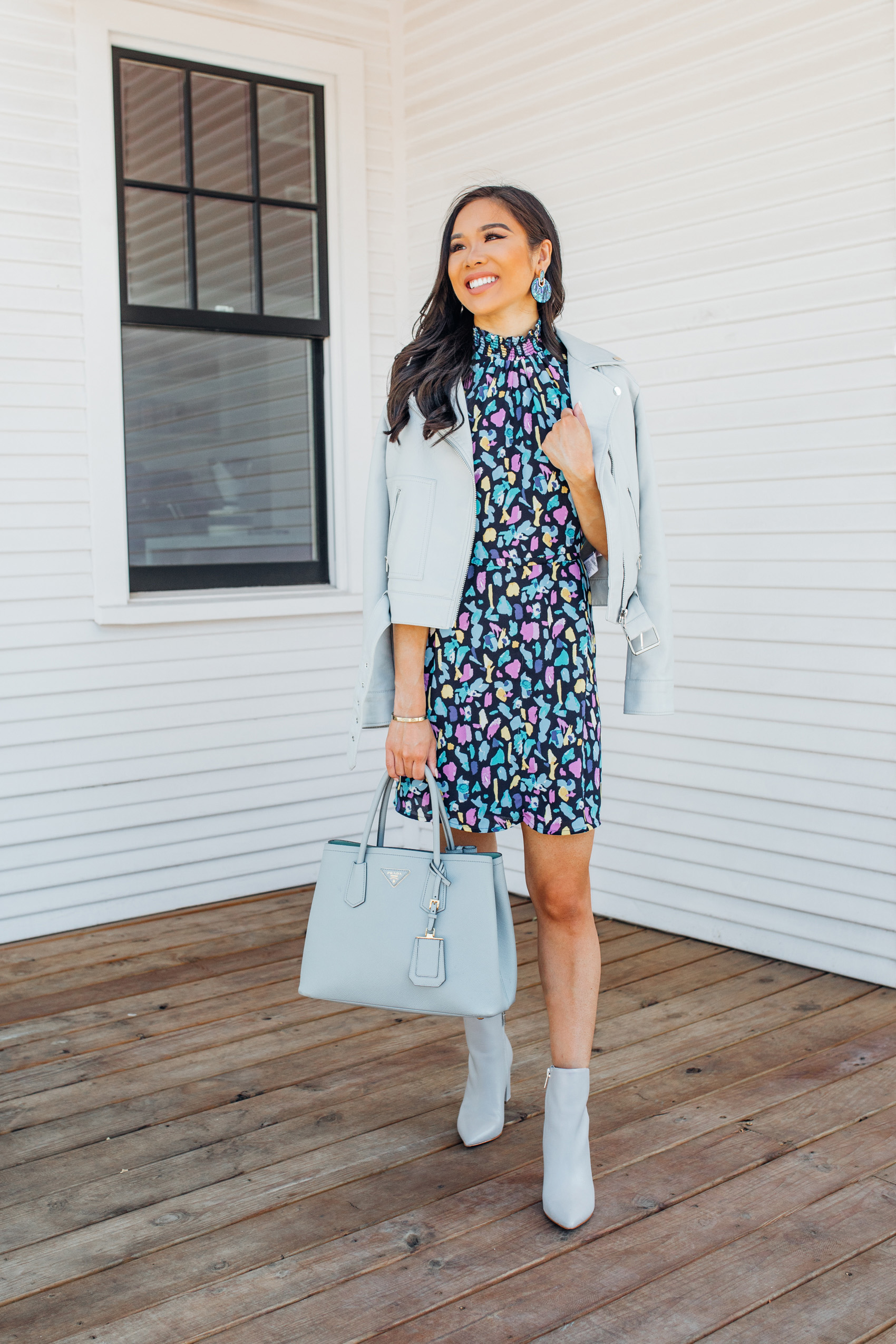 Petite blogger wears a printed mock neck dress with a gray leather motorcycle outfit, gray booties and Kendra Scott didi earrings for a fall outfit