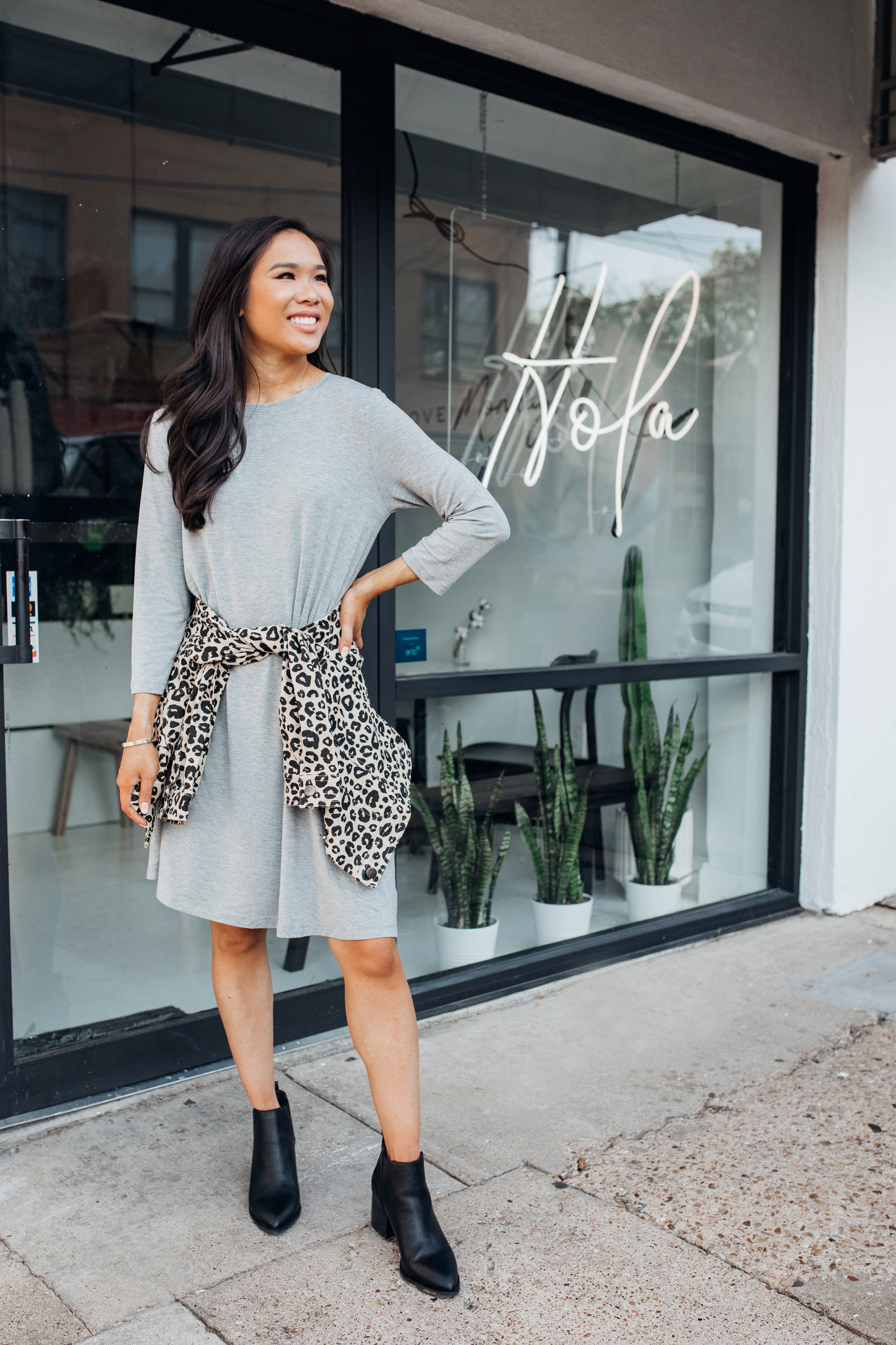 Blogger Hoang-Kim shares affordable fall fashion with Walmart wearing a gray shirt dress, leopard jacket and black booties for a fall outfit