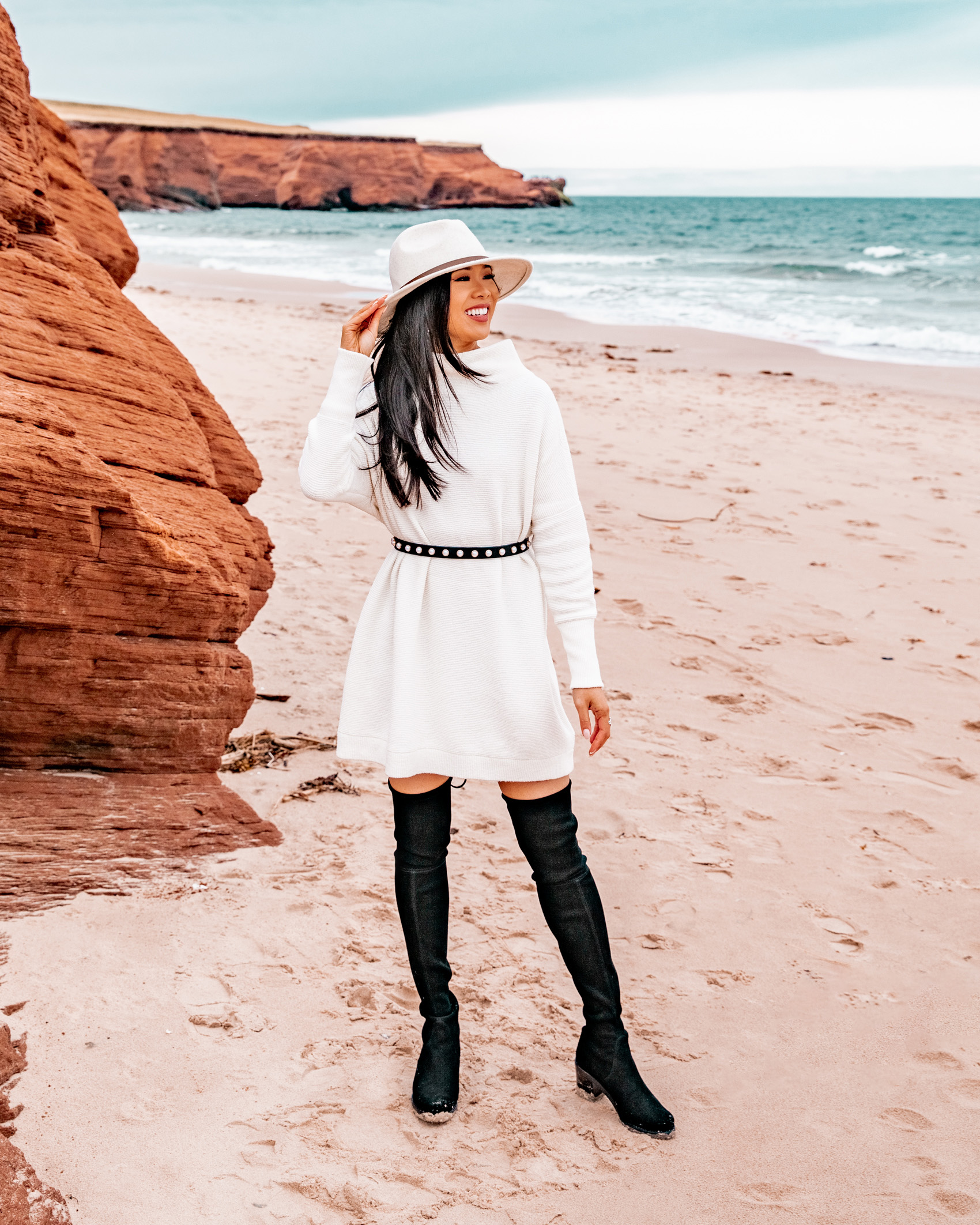 White sweater dress with suede over the knee boots and a cream hat by Petite blogger Hoang-Kim